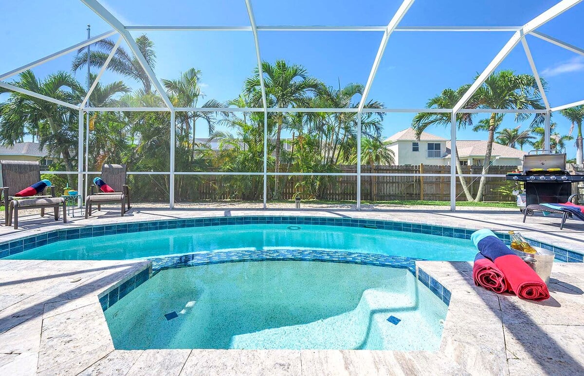 Privater Pool mit Whirlpool und Sonnenliegen auf der Terrasse am Kanal.