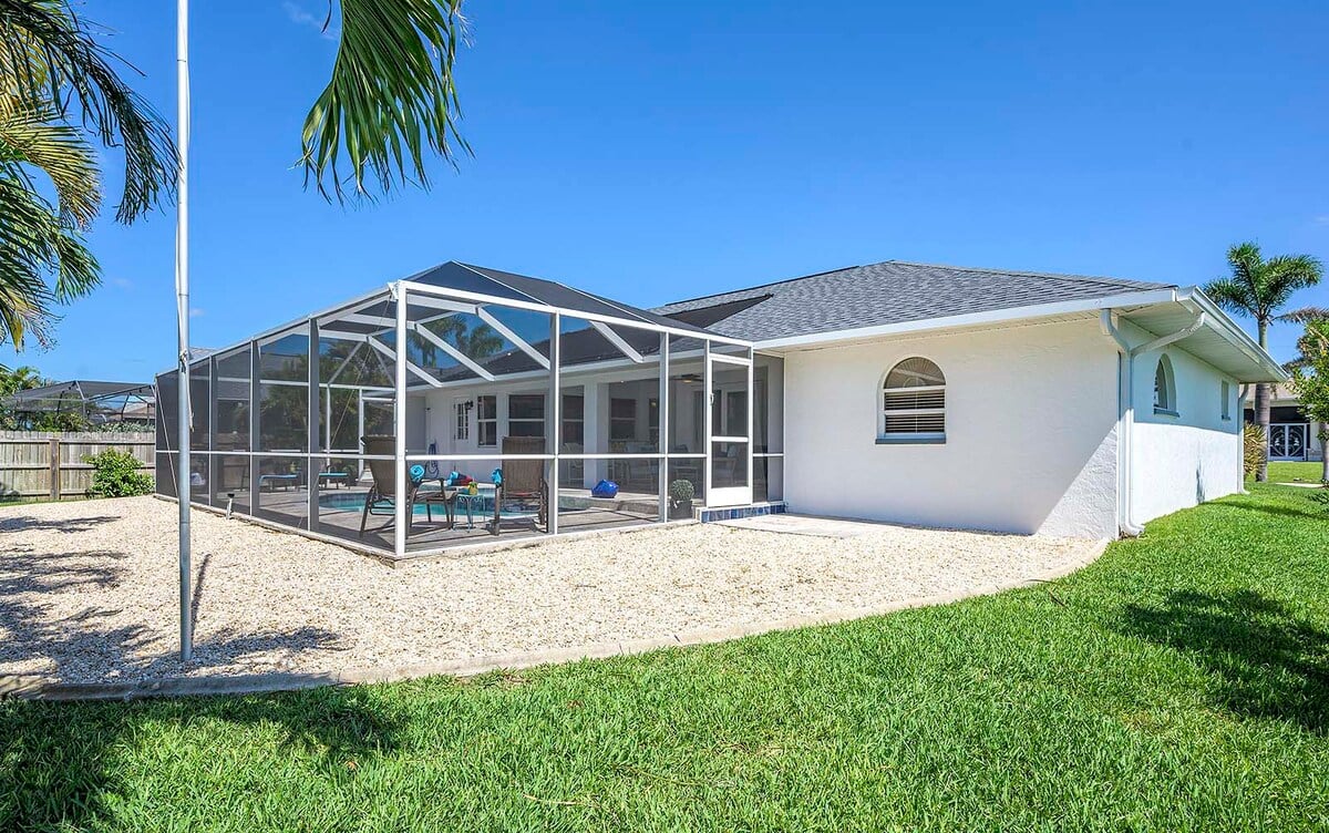 Überdachte Terrasse am Kanal mit Pool, Whirlpool und Sonnenliegen.