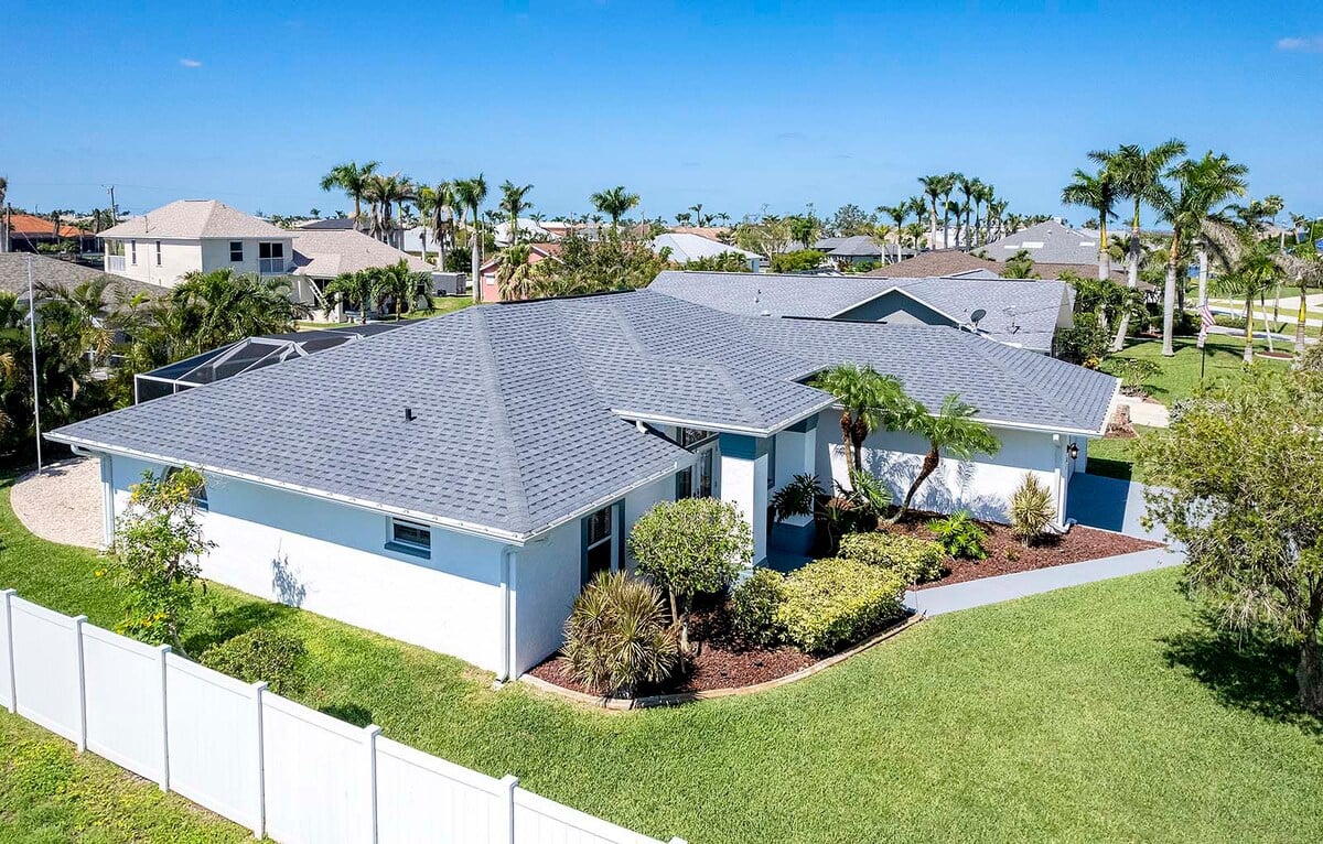 Pool- und Terrassenbereich am Kanal mit Sonnenliegen, Esstisch und Grill.