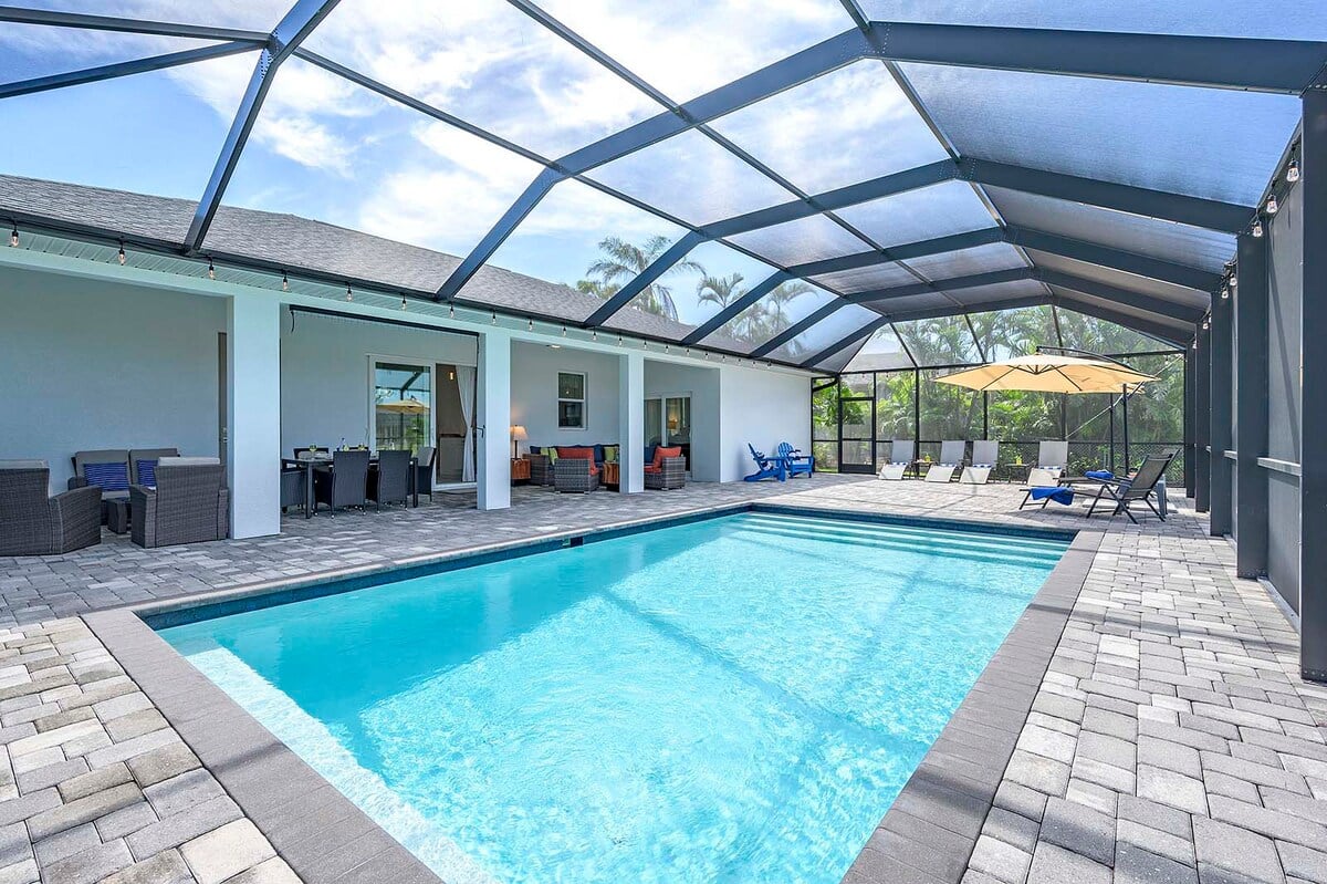 Beheizter Pool mit Lanai und Sitzbereich im Garten.