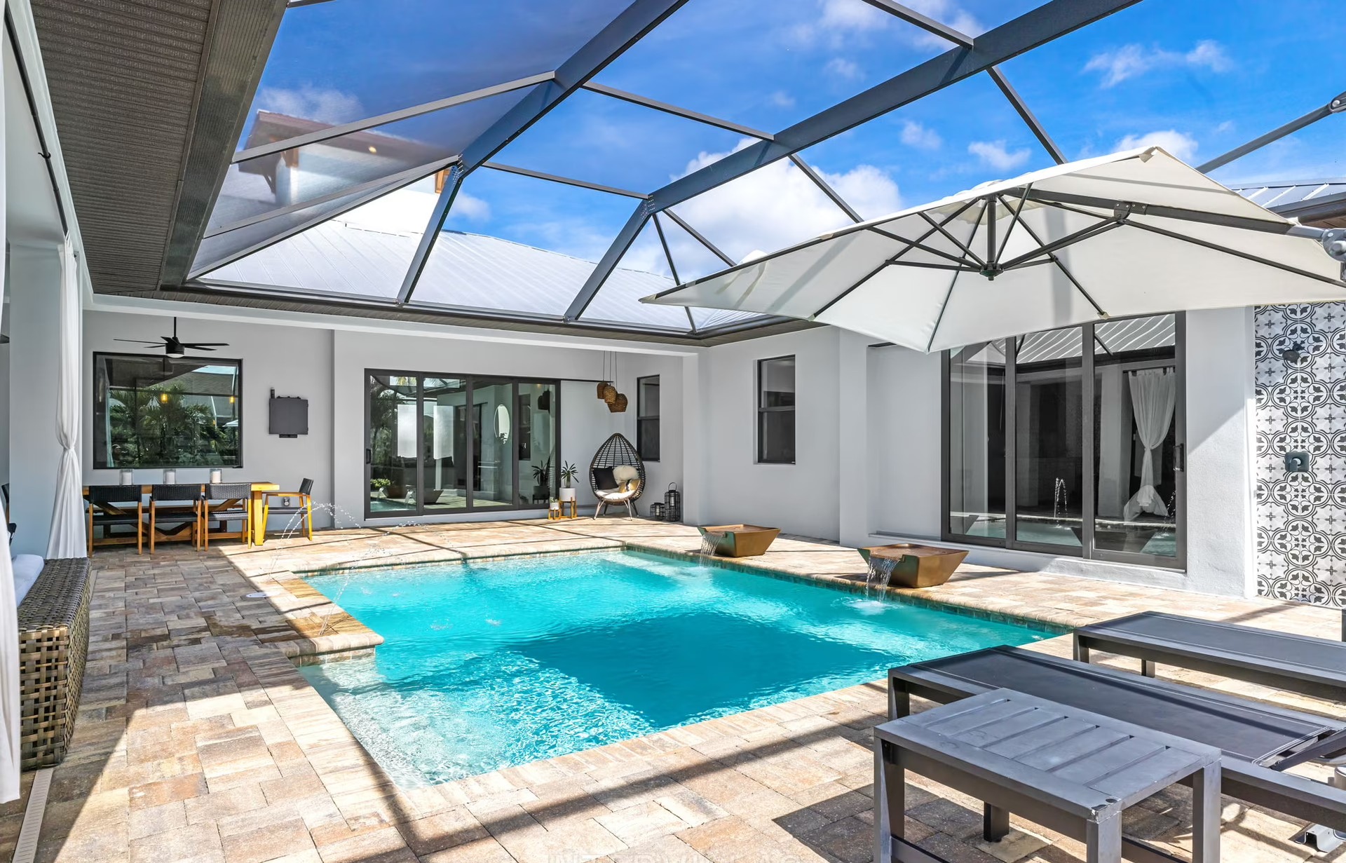 Outdoor-Bereich mit beheiztem Pool, Outdoor-Küche und überdachtem Sitzplatz.