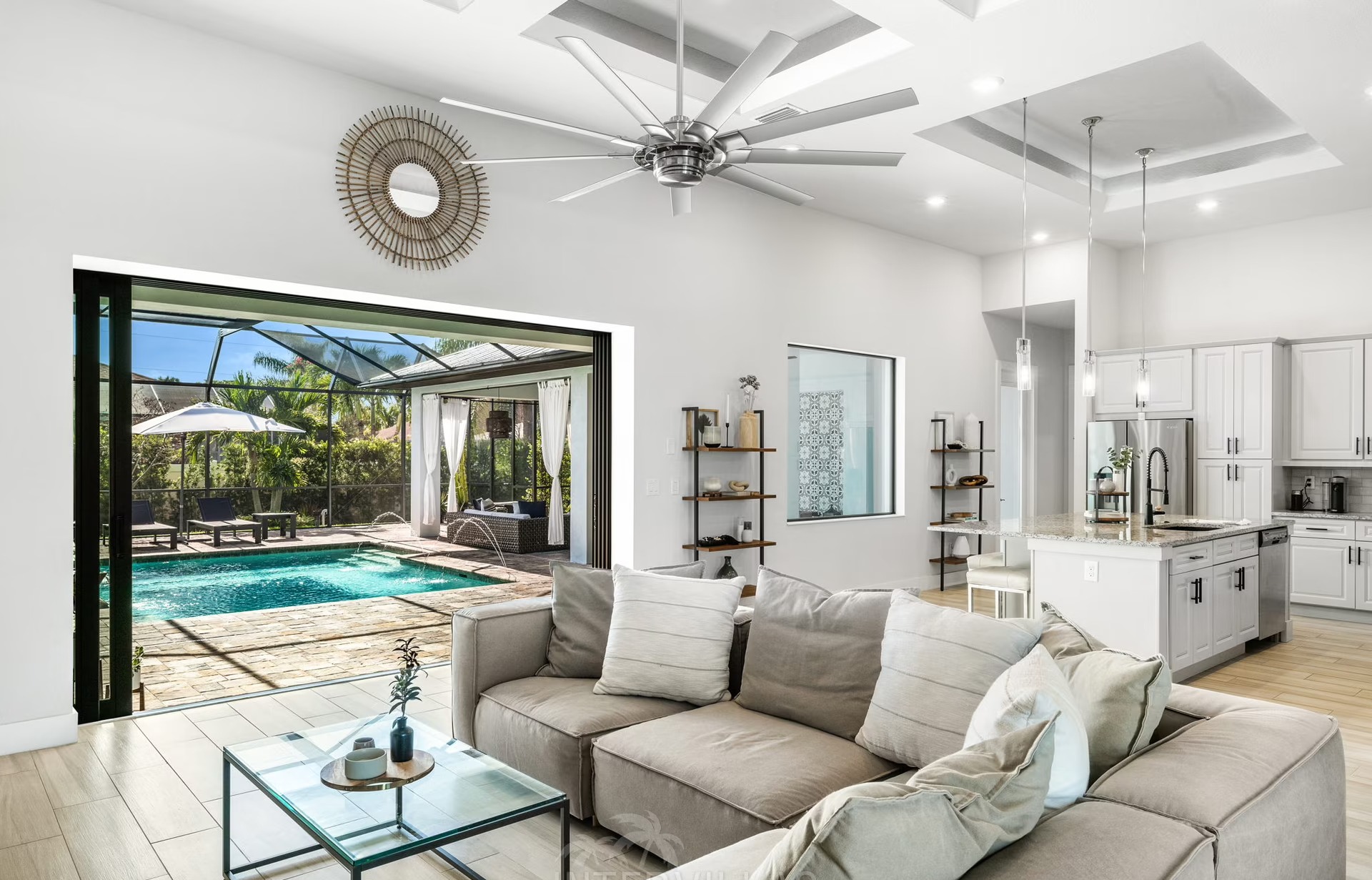 Beheizter Pool mit Liegen und Outdoor-Küche im überdachten Terrassenbereich.