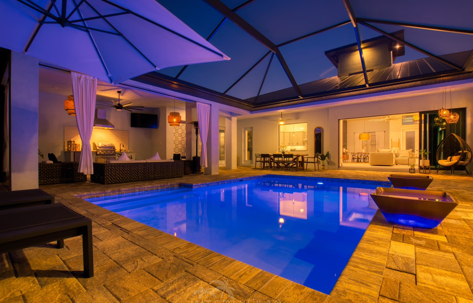 Beheizter Pool mit Liegen und überdachtem Sitzbereich sowie Outdoor-Küche.