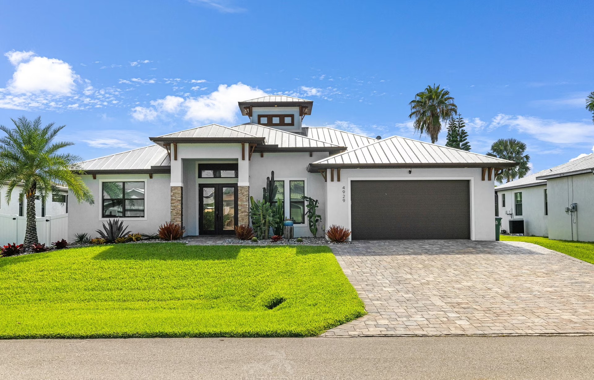 Outdoor-Bereich mit beheiztem Pool, Liegen und Outdoor-Küche mit Grill.