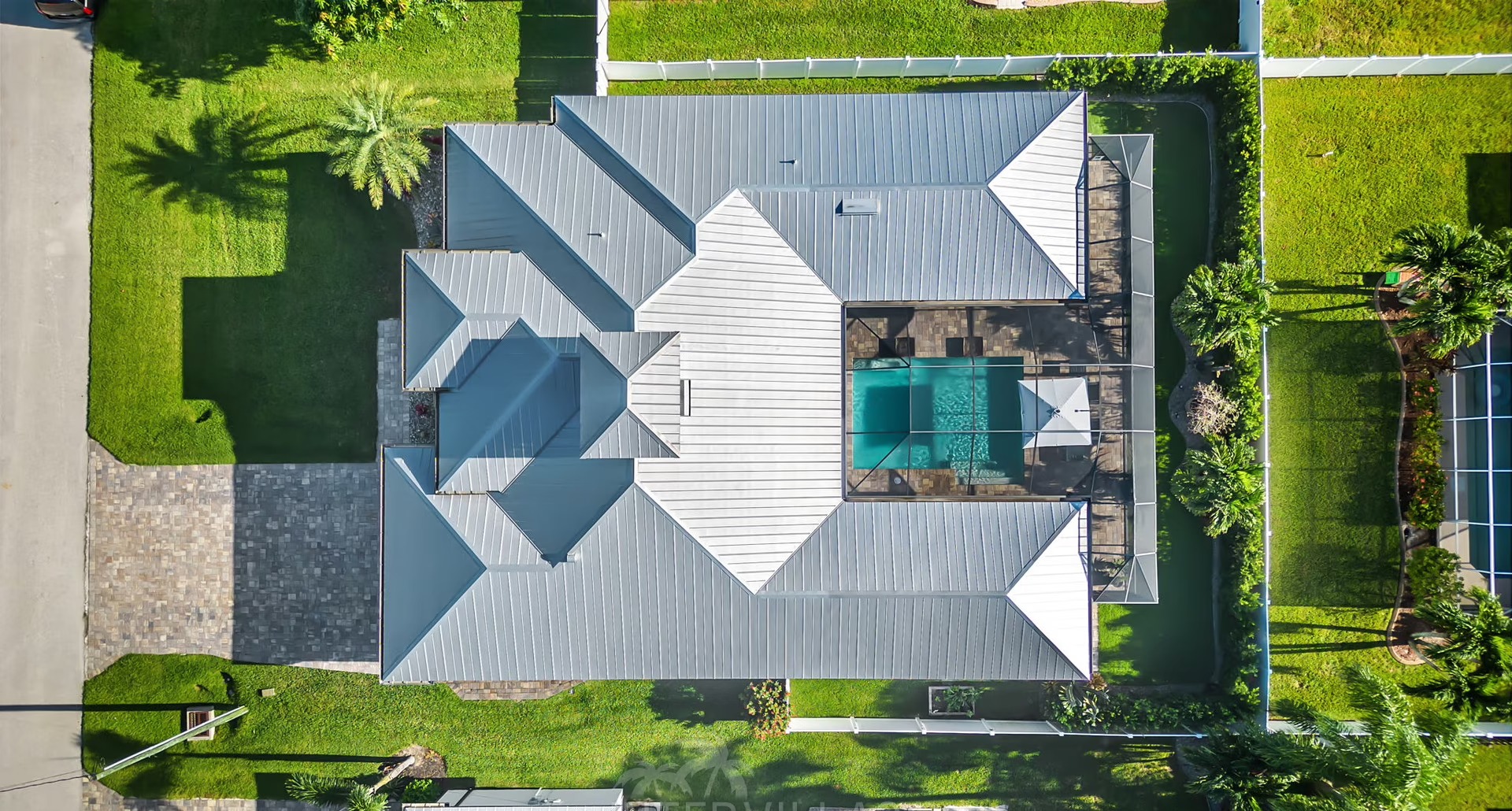 Outdoor-Bereich mit beheiztem Pool, Outdoor-Küche und überdachtem Sitzplatz.