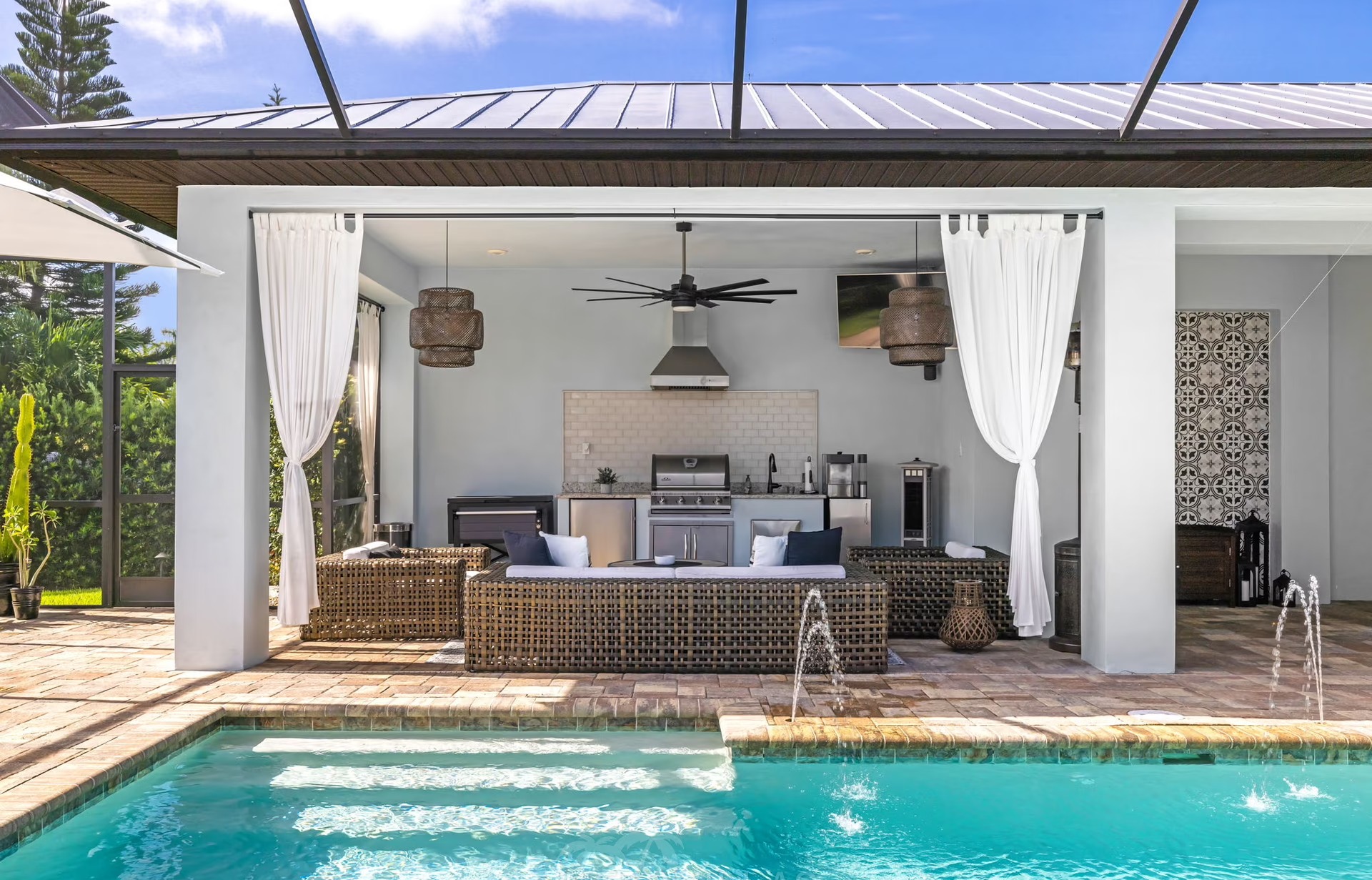 Poolbereich mit beheiztem Pool, Outdoor-Küche und überdachtem Sitzplatz.