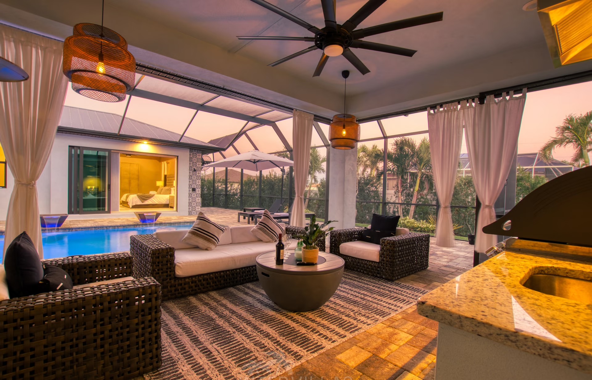 Poolbereich mit BBQ und Outdoor-Küche unter überdachtem Sitzbereich