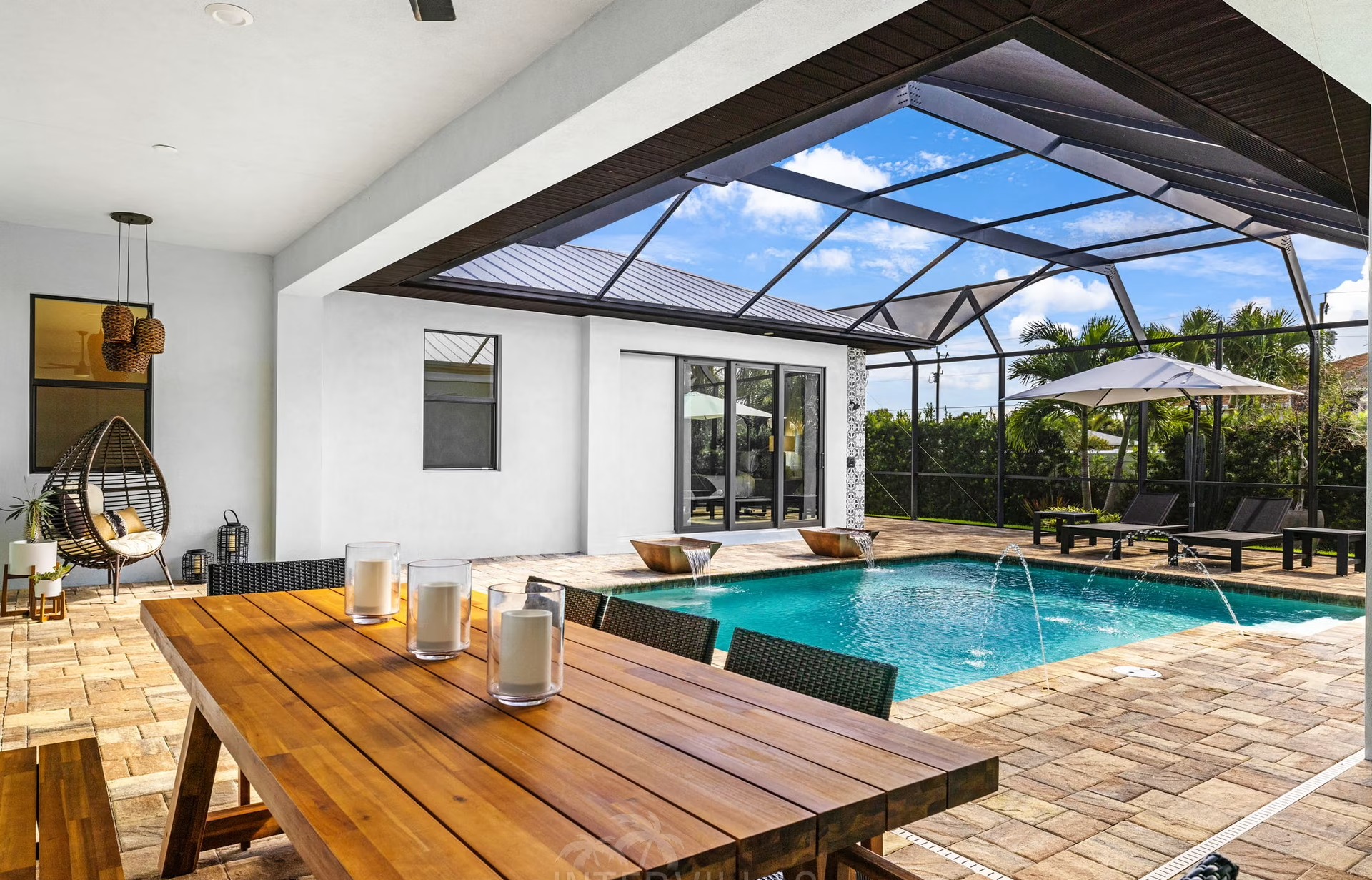 Outdoor-Bereich mit beheiztem Pool, Liegen und Outdoor-Küche mit Grill.