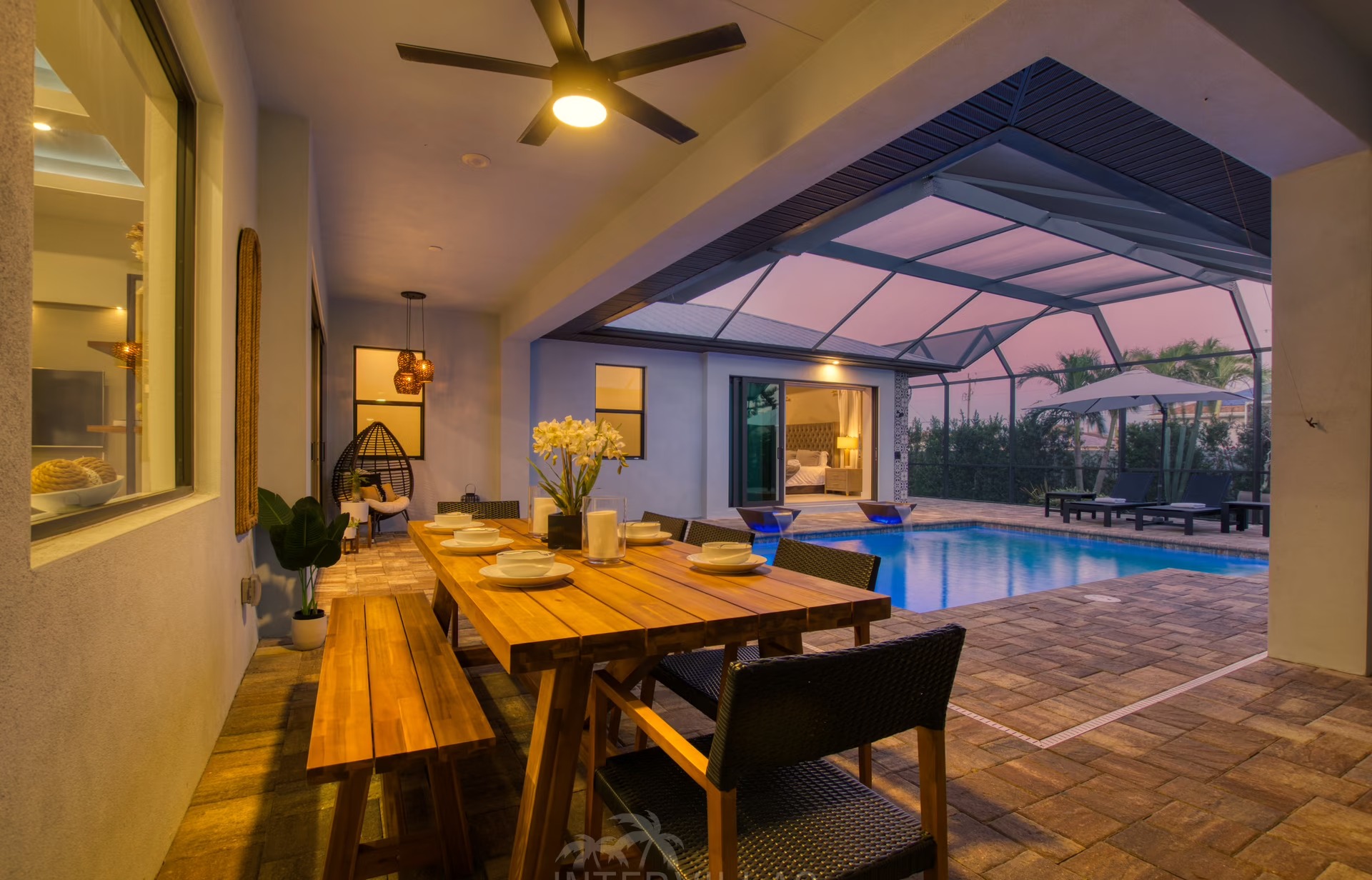 Überdachter Poolbereich mit Liegen und Outdoor-Küche am Haus.