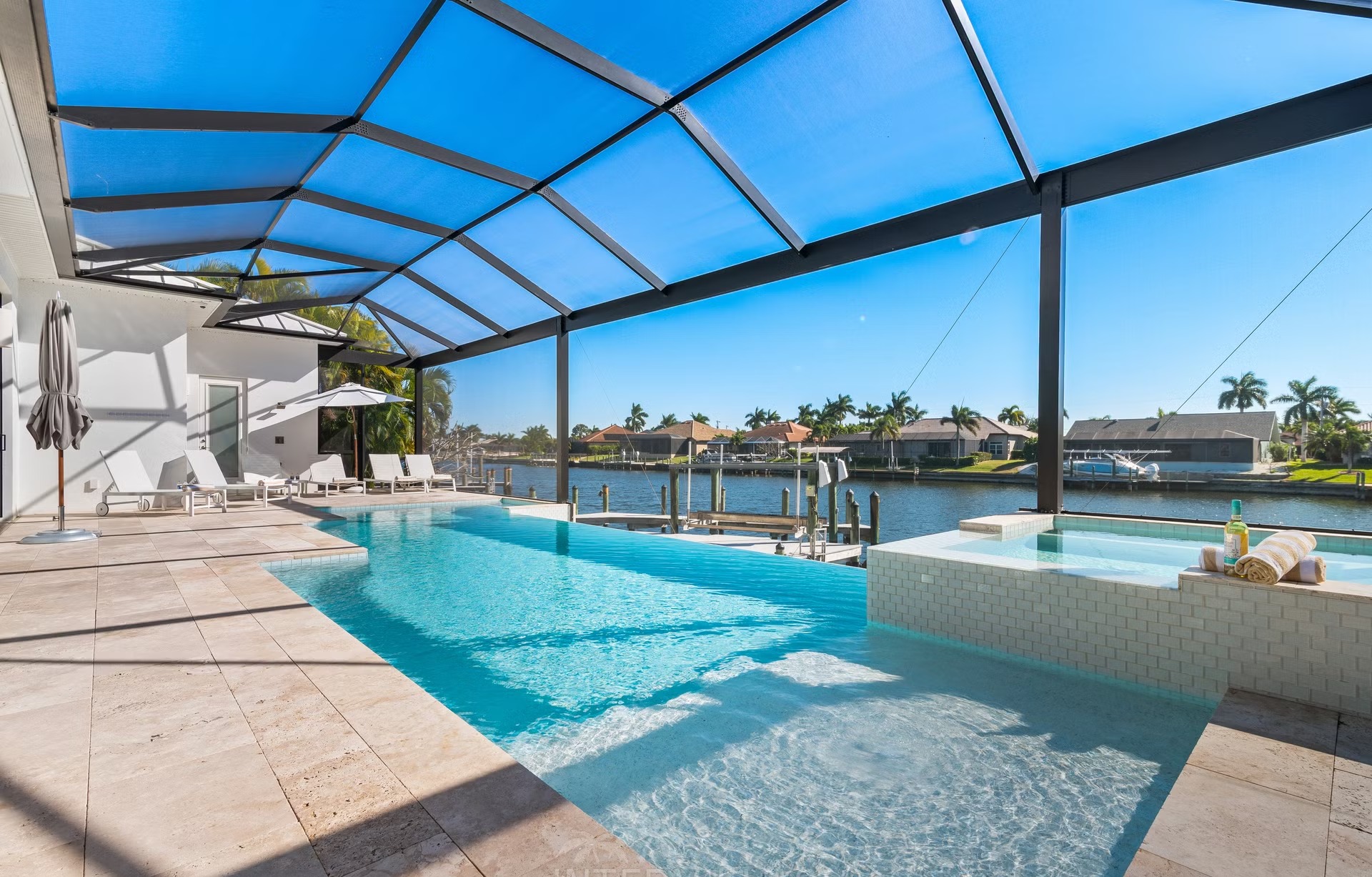 Moderne Villa am Kanal mit Bootsanleger und Blick aufs Wasser.