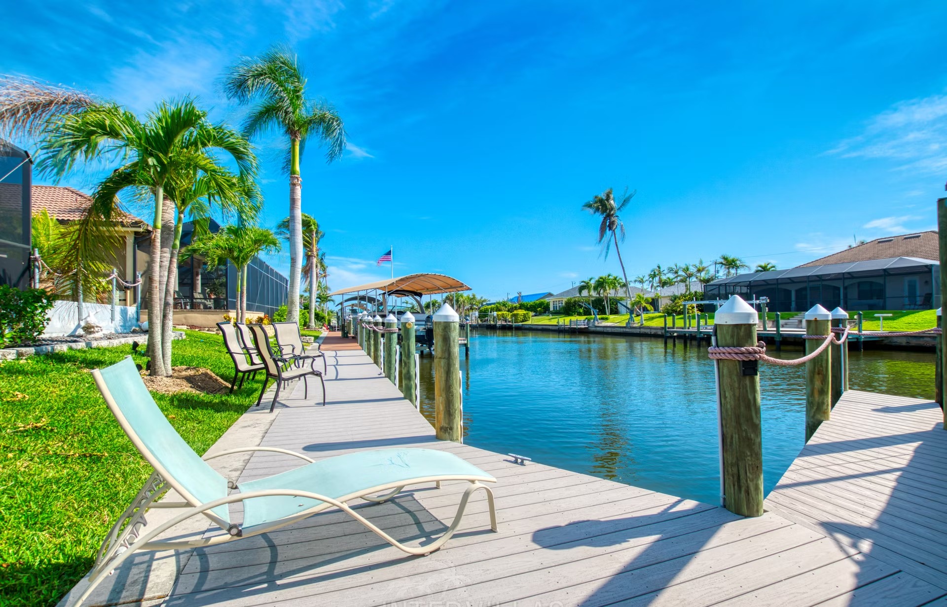 Beheizter Pool mit Liegen und überdachtem Sitzbereich am Kanal mit Bootsdock.