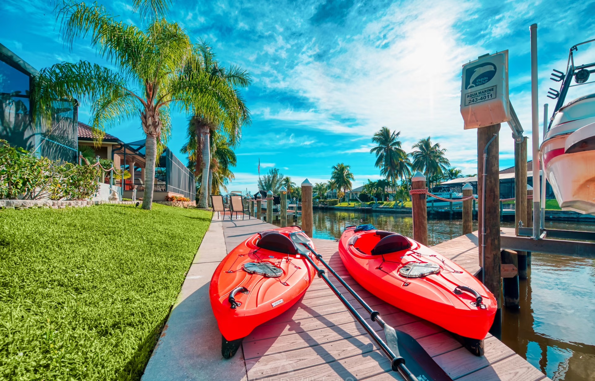 Beheizter Pool mit Liegen und überdachtem Sitzbereich am Kanal mit privatem Bootsdock.