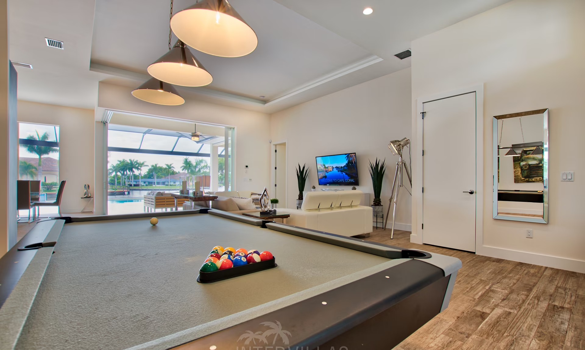 Moderne Villa am Kanal mit sonnigem Poolbereich und Wasserblick.