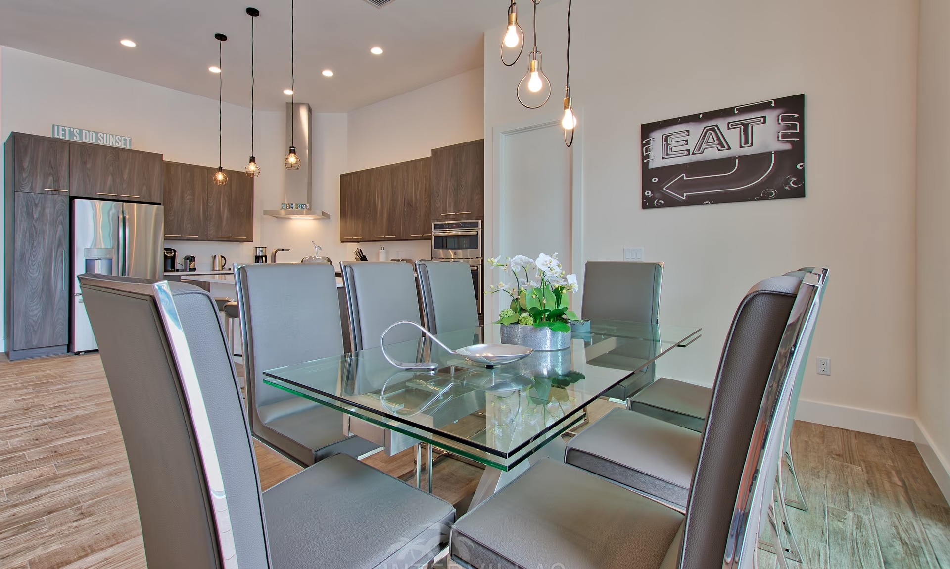 Moderne Villa am Kanal mit sonnigem Poolbereich und Blick aufs Wasser.