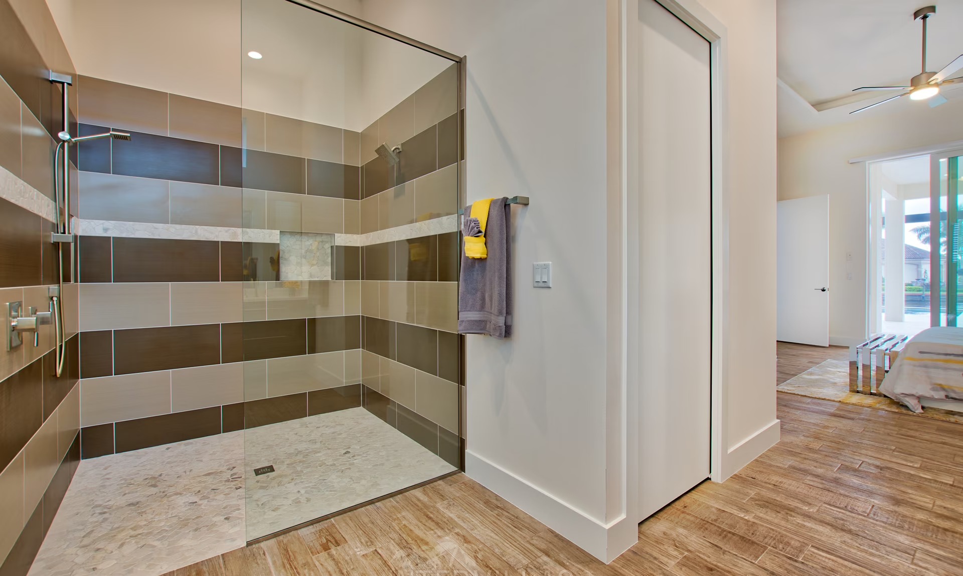 Moderne Villa am Kanal mit sonnigem Poolbereich und Blick aufs Wasser.