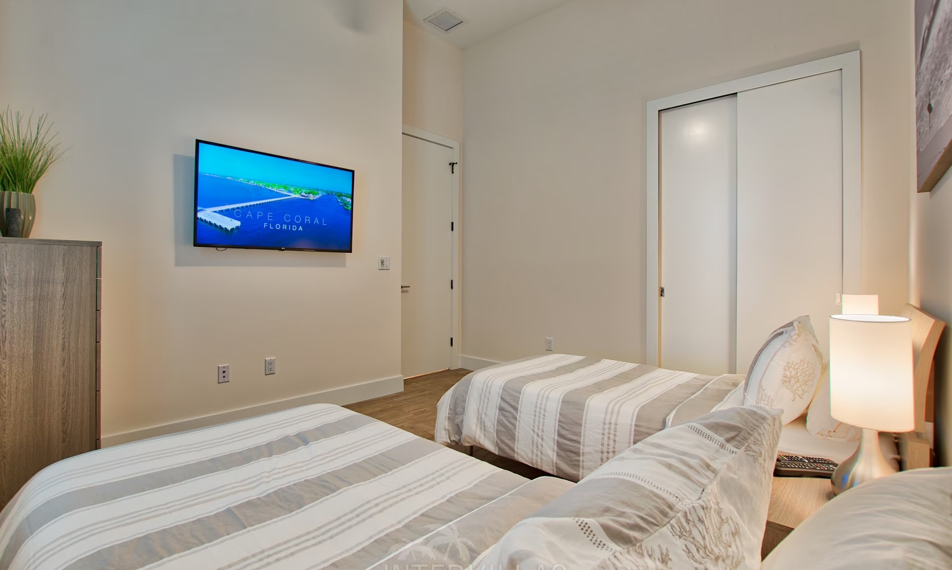 Moderne Villa am Kanal mit sonnigem Poolbereich und Blick aufs Wasser.