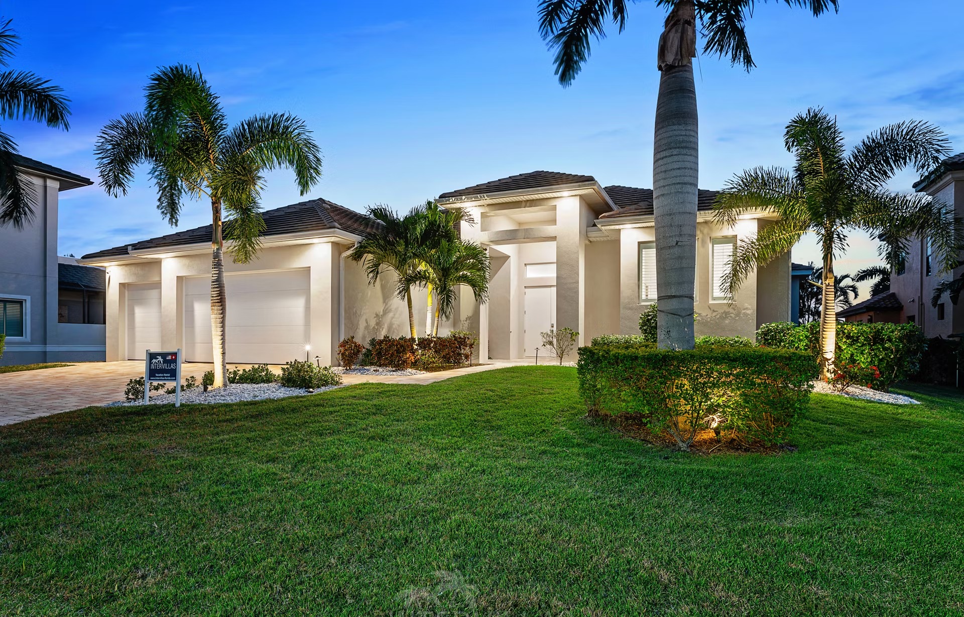 Moderne Villa am Kanal mit sonnigem Poolbereich und Blick aufs Wasser.