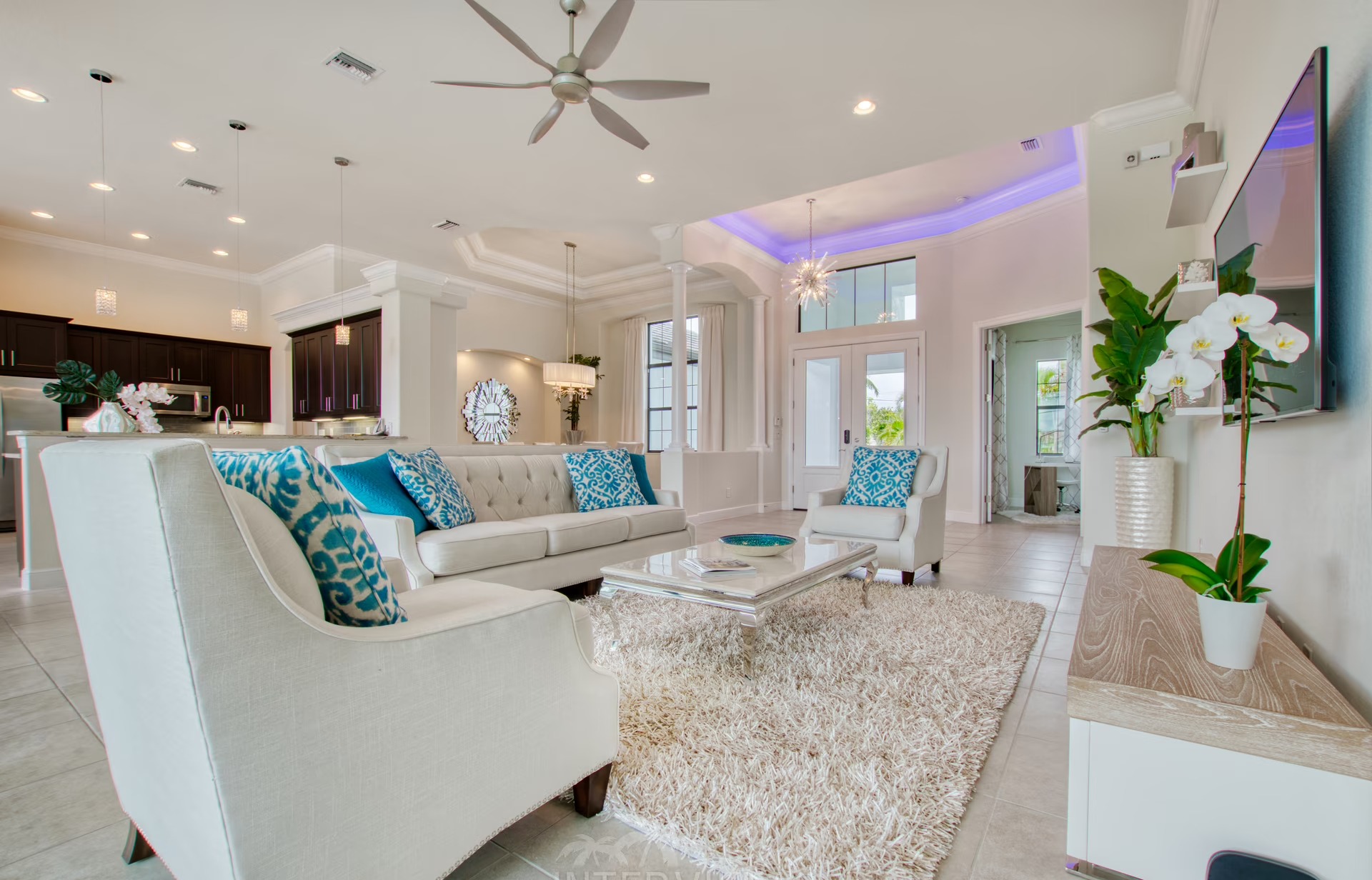 Heller Wohnbereich mit großen Schiebetüren und Blick auf Pool und Kanal.