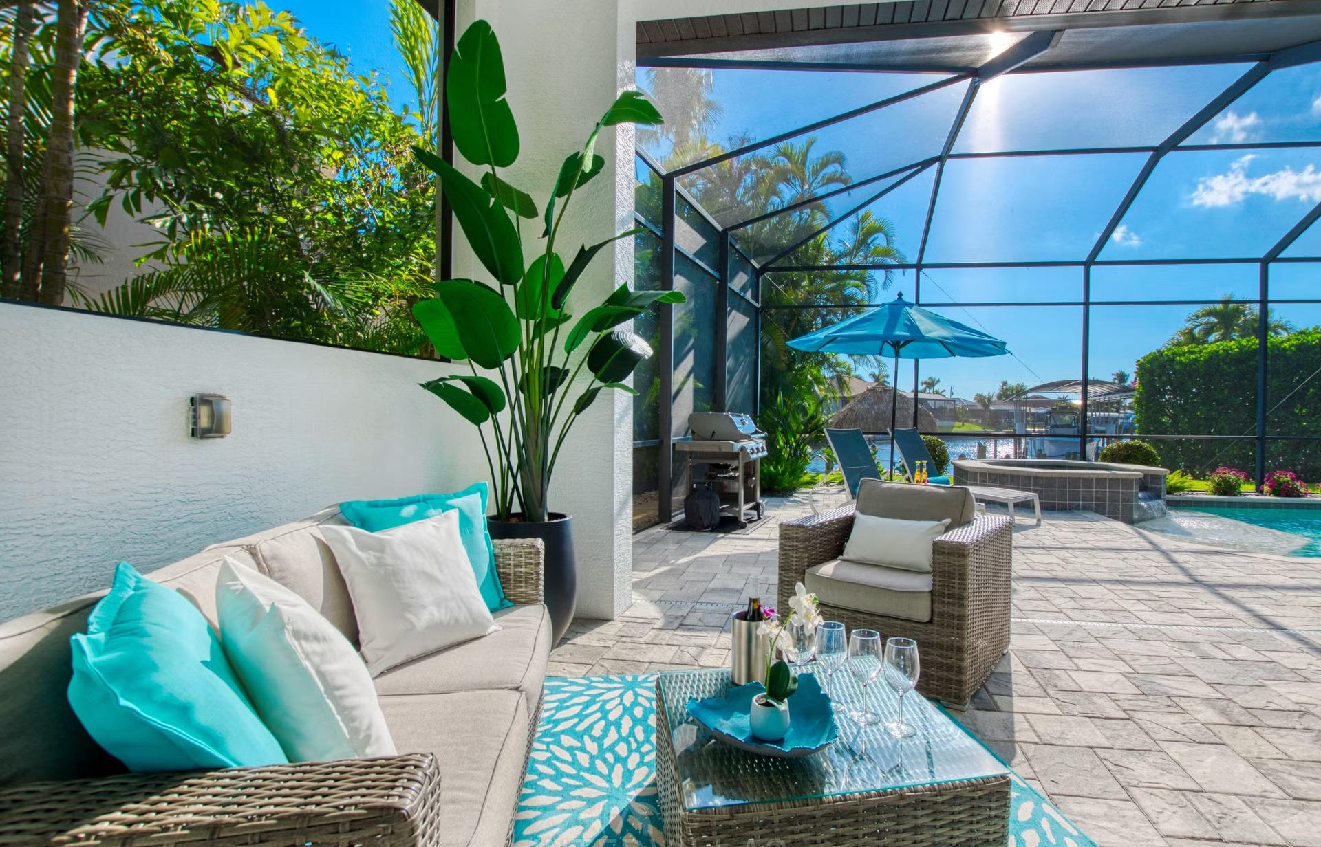 Heller Wohnbereich mit offener Küche und Blick auf den Poolbereich.