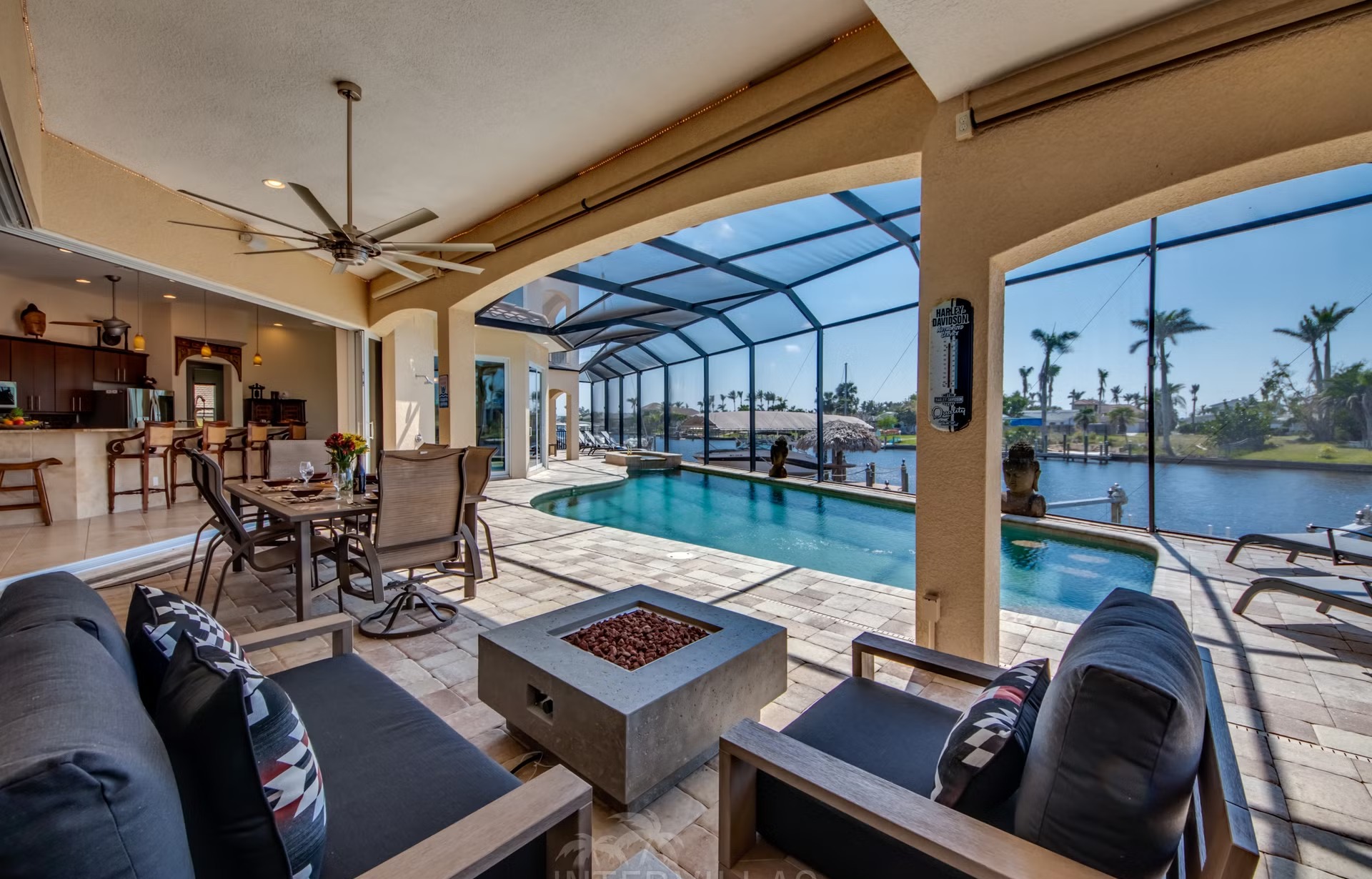 Dock am Kanal mit Tiki-Hut und Kajaks am Wasser.