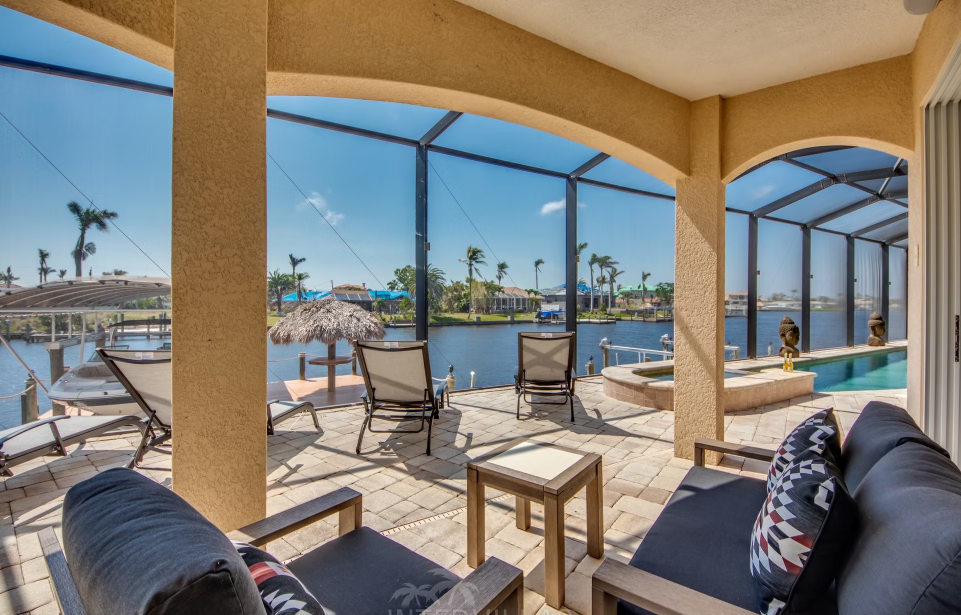 Dock am Kanal mit Tiki-Hut, Bootslift und bereitliegenden Kajaks.