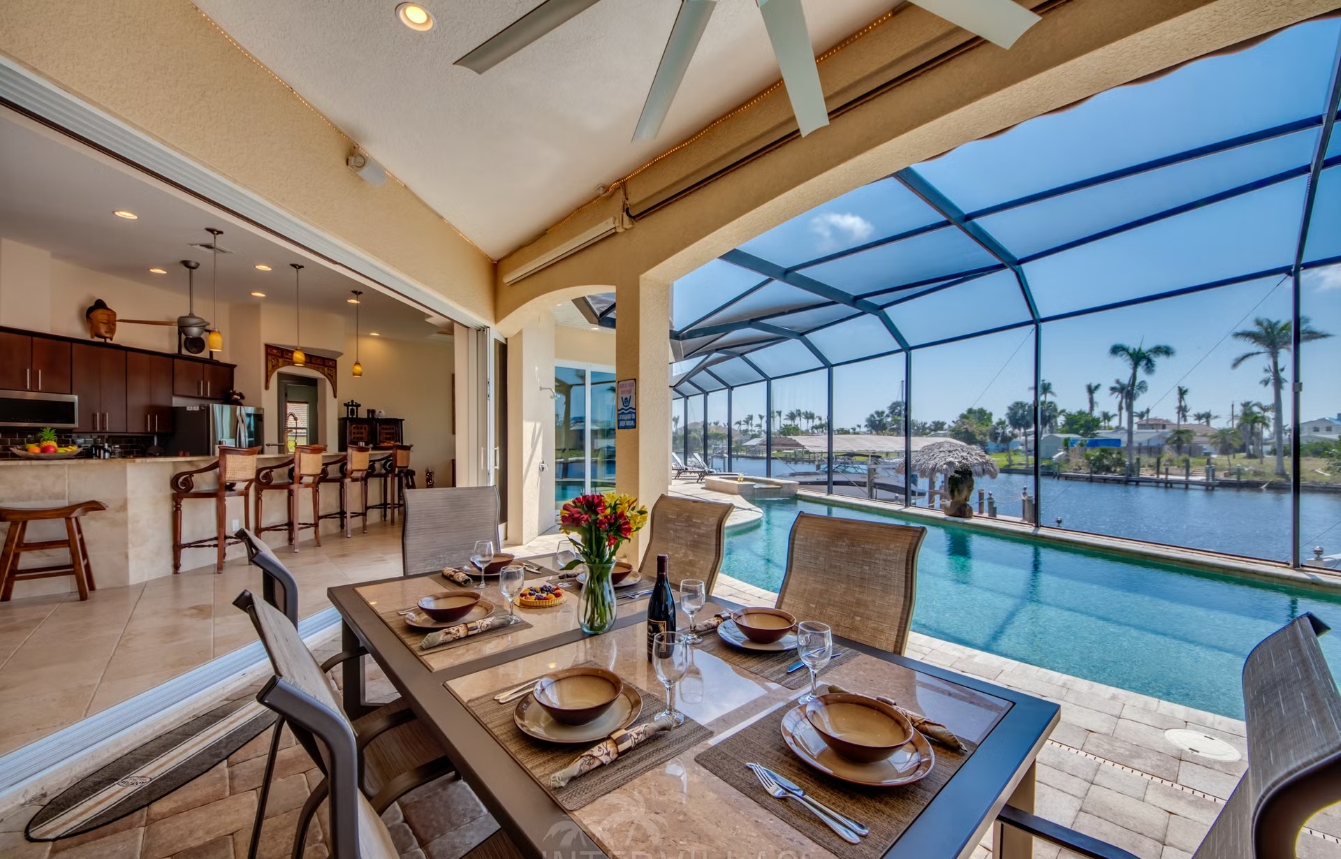 Dock mit Tiki-Hut am Kanal, daneben Kajaks am Wasser.