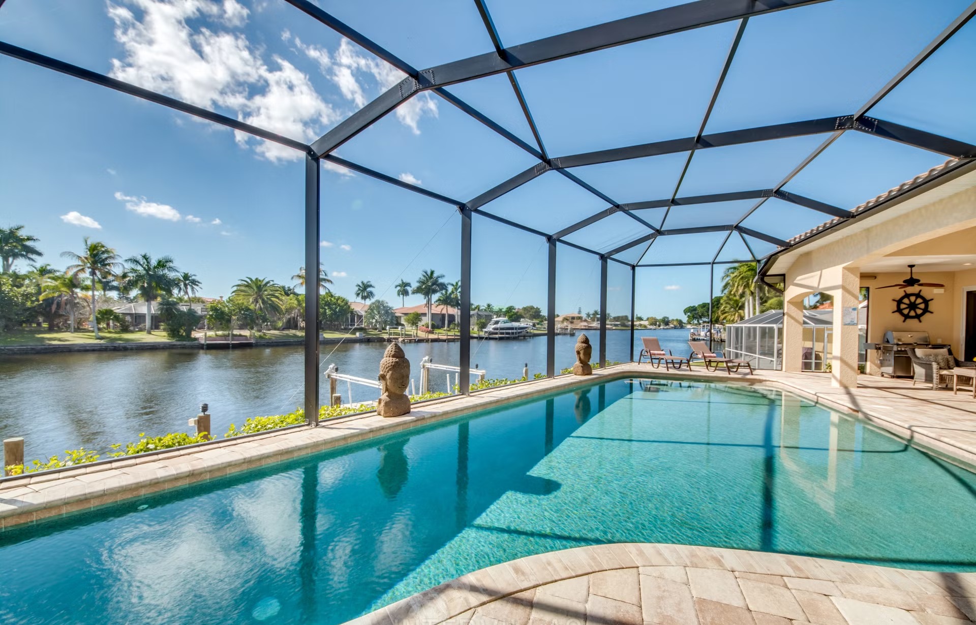Dock mit Tiki-Hut am breiten Kanal, daneben Kajaks am Wasser.