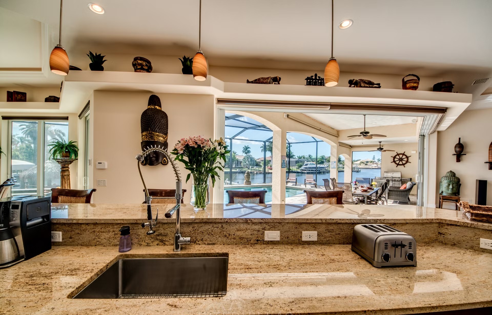 Dock mit Tiki-Hut am Kanal, Kajaks am Steg.