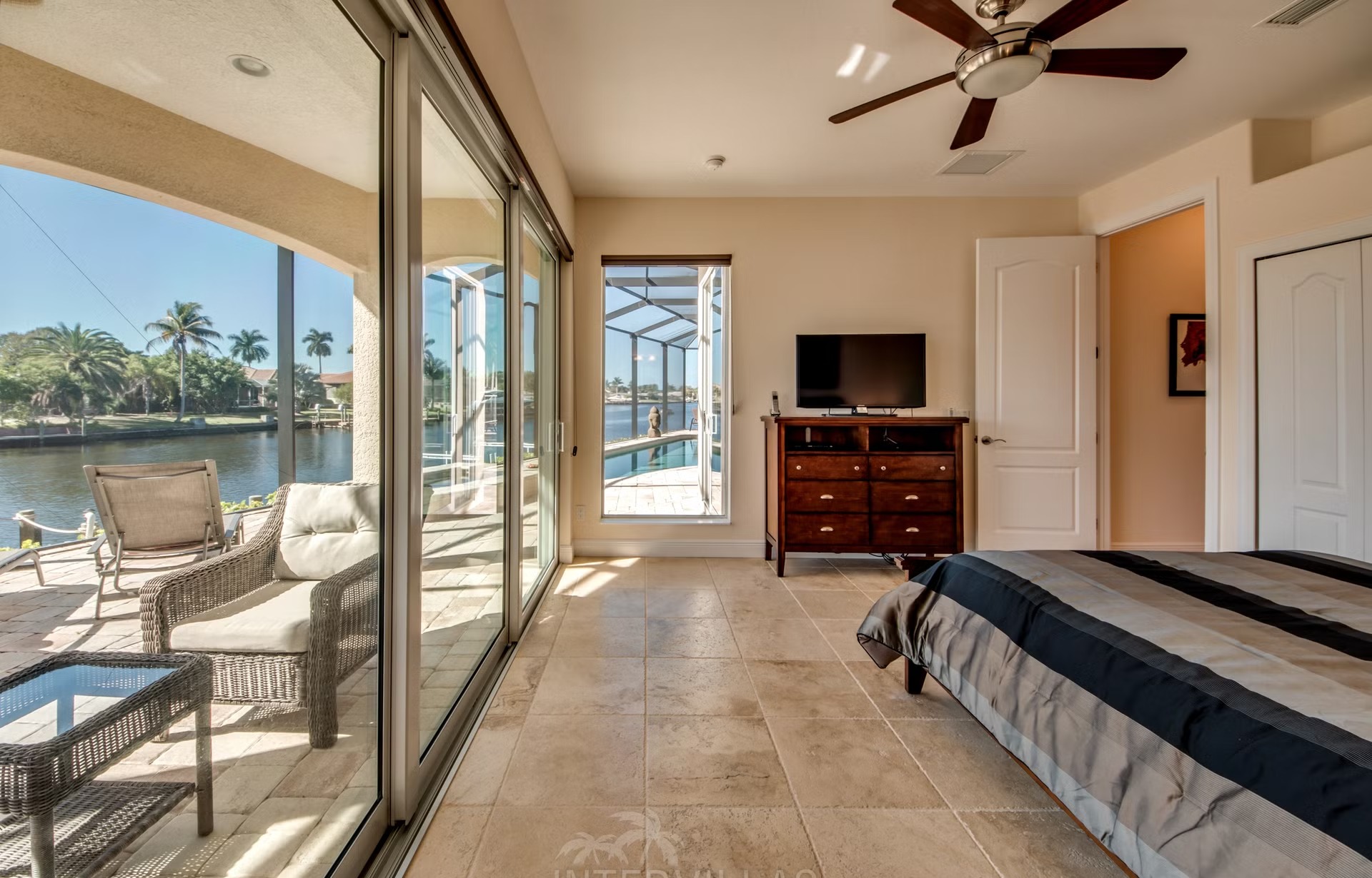 Dock mit Tiki-Hut am breiten Kanal, mit Kajaks und Bootslift.