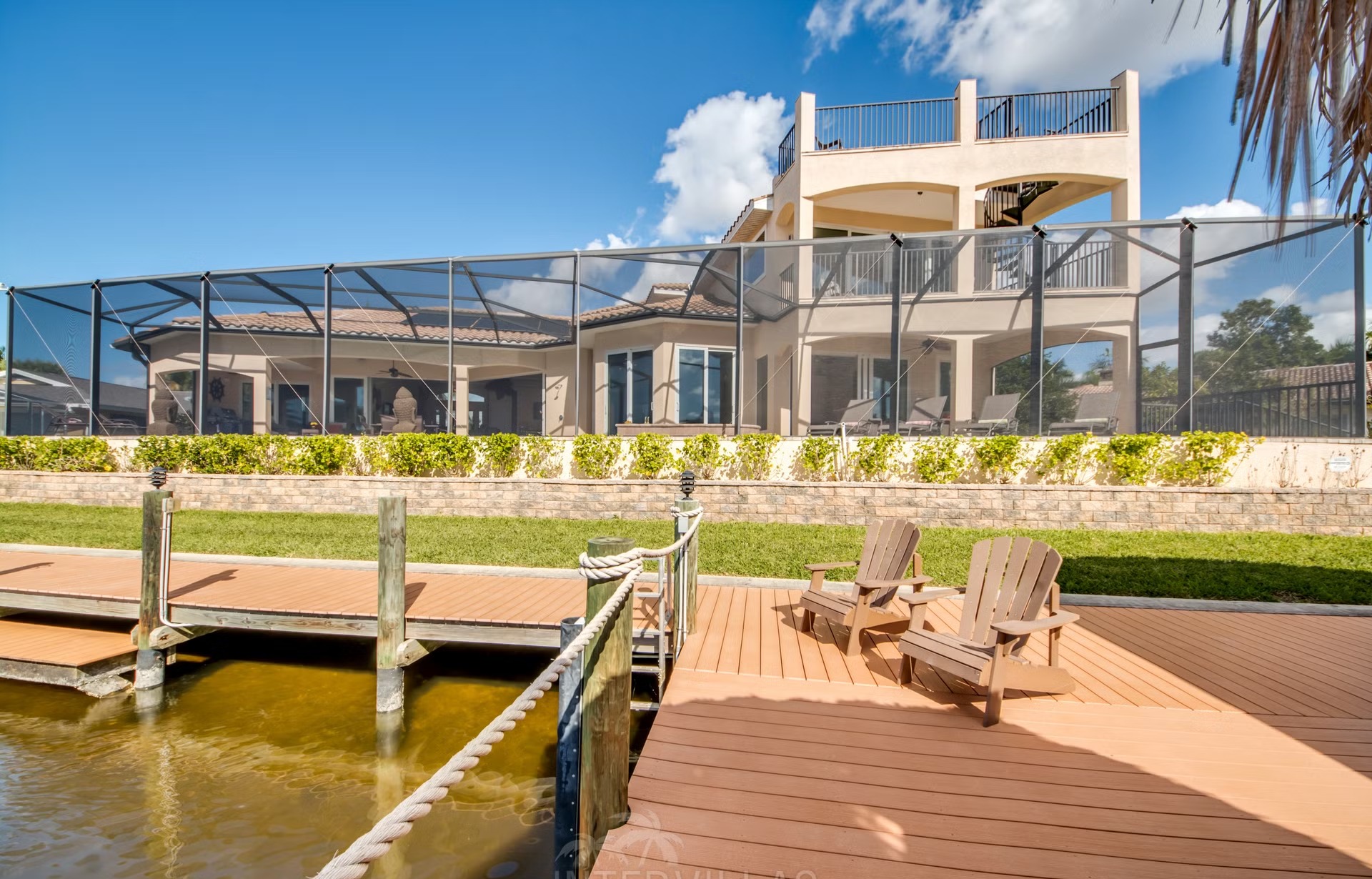 Dock am Kanal mit Tiki-Hut, Bootslift und bereitliegenden Kajaks.