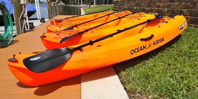 Dock mit Tiki-Hut am Kanal, daneben Kajaks am Wasser.