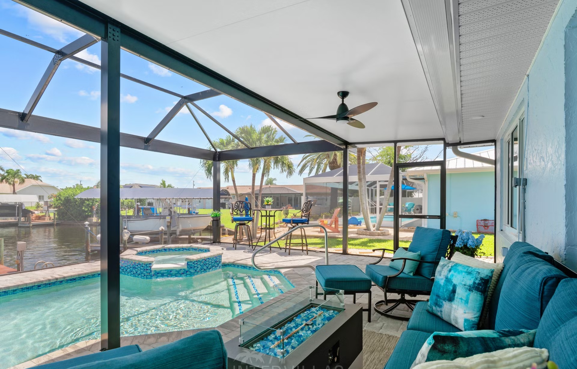 Pool- und Spa-Bereich am Wasser mit Outdoor-Lounge und Dock.