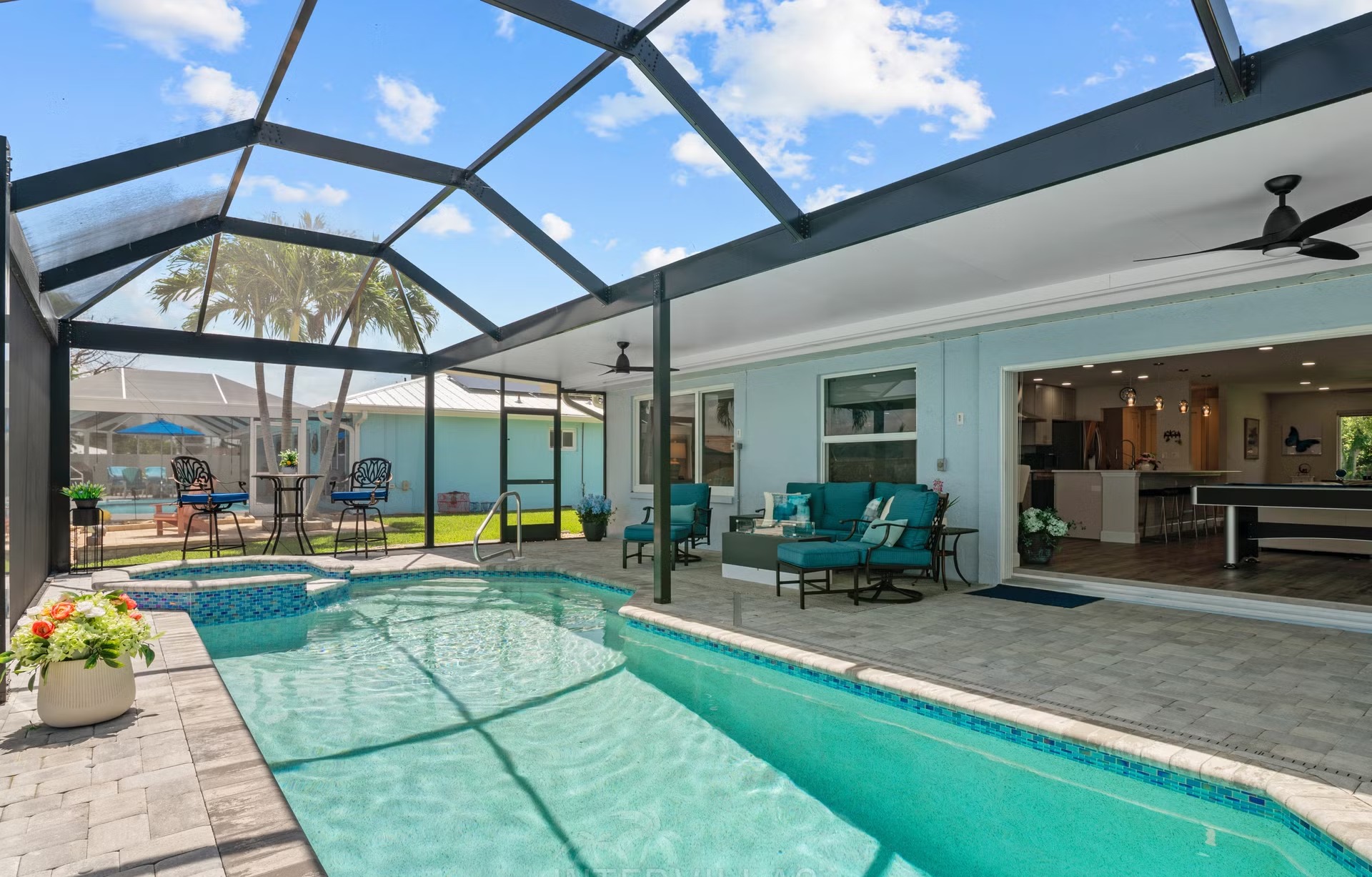 Pool- und Spa-Bereich am Wasser mit Outdoor-Lounge und Blick auf den Kanal