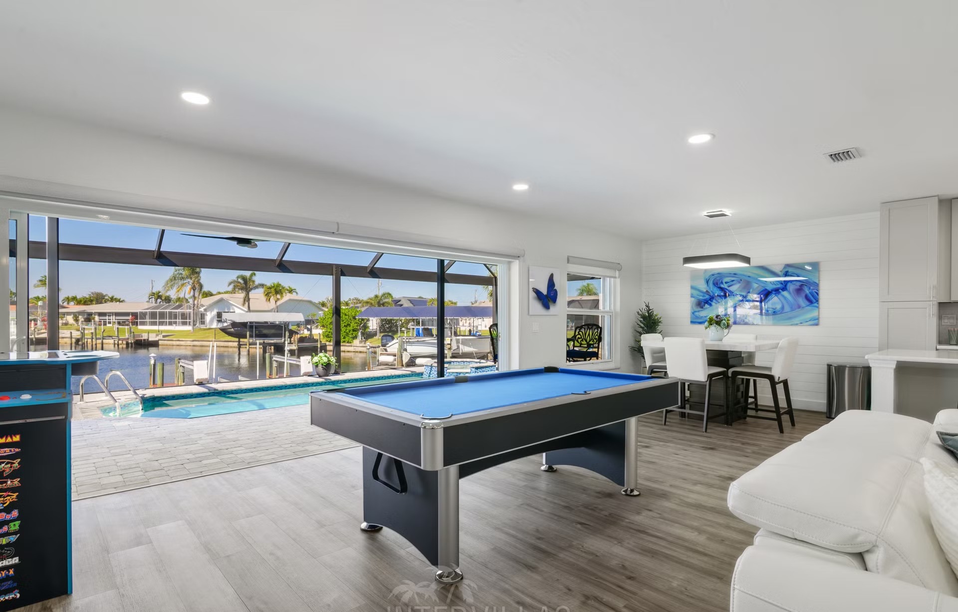 Pool- und Spa-Bereich am Wasser mit Outdoor-Lounge und Blick auf den Kanal