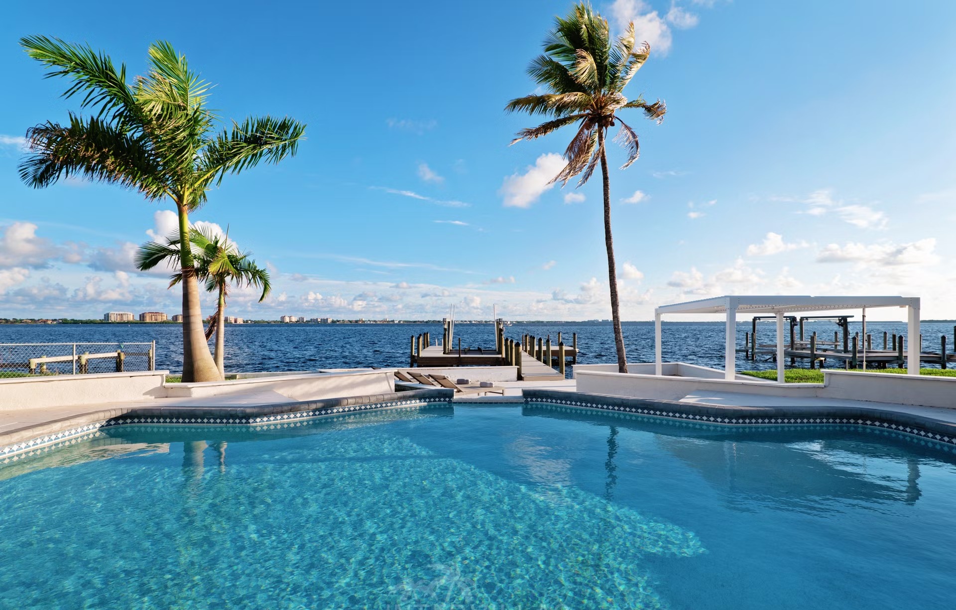 Beheizter Salzwasserpool mit Liegen und Blick auf den Fluss.