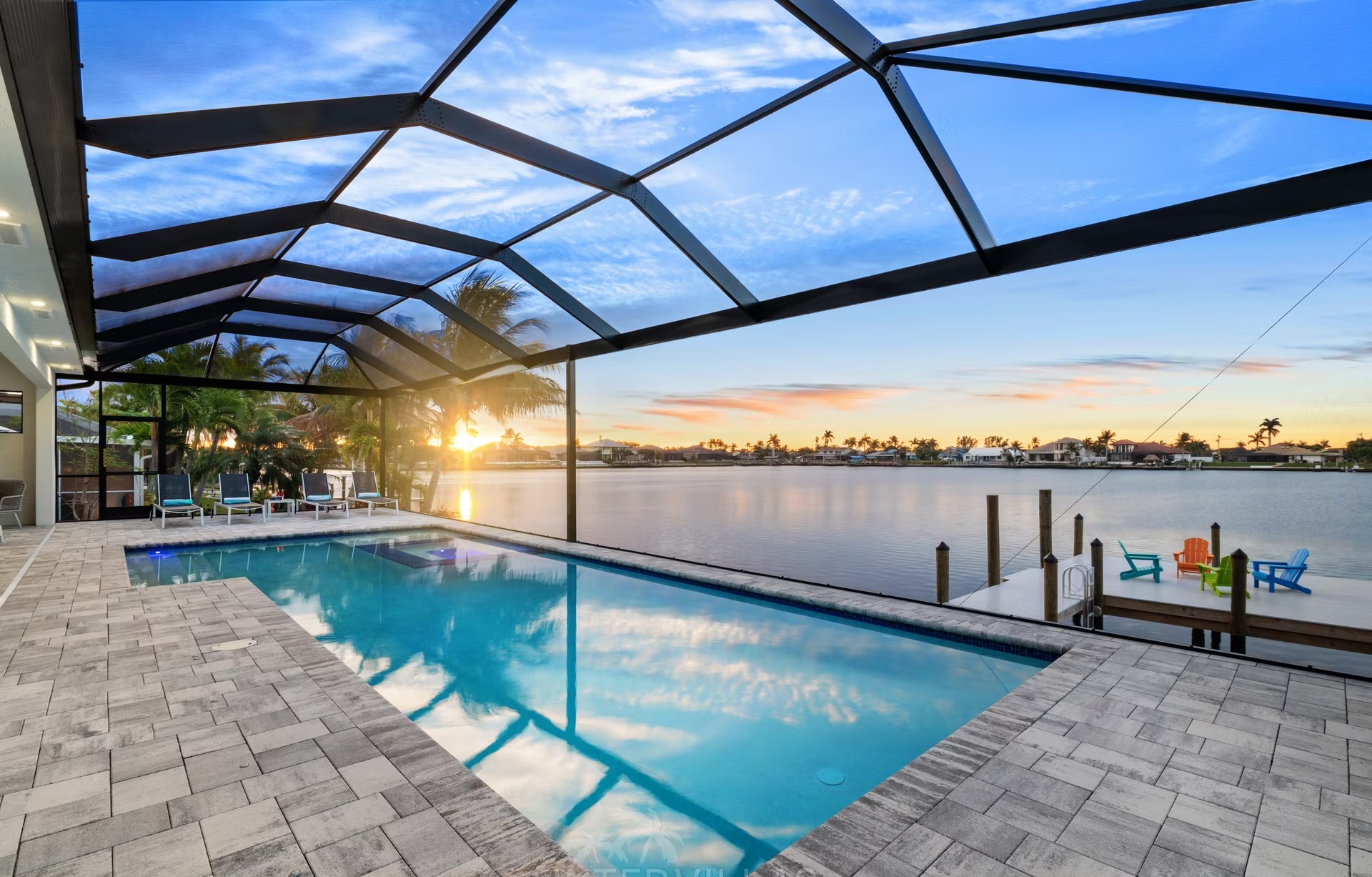 Sonnige Poolterrasse mit Salzwasser-Pool, Spa und Blick aufs Wasser.