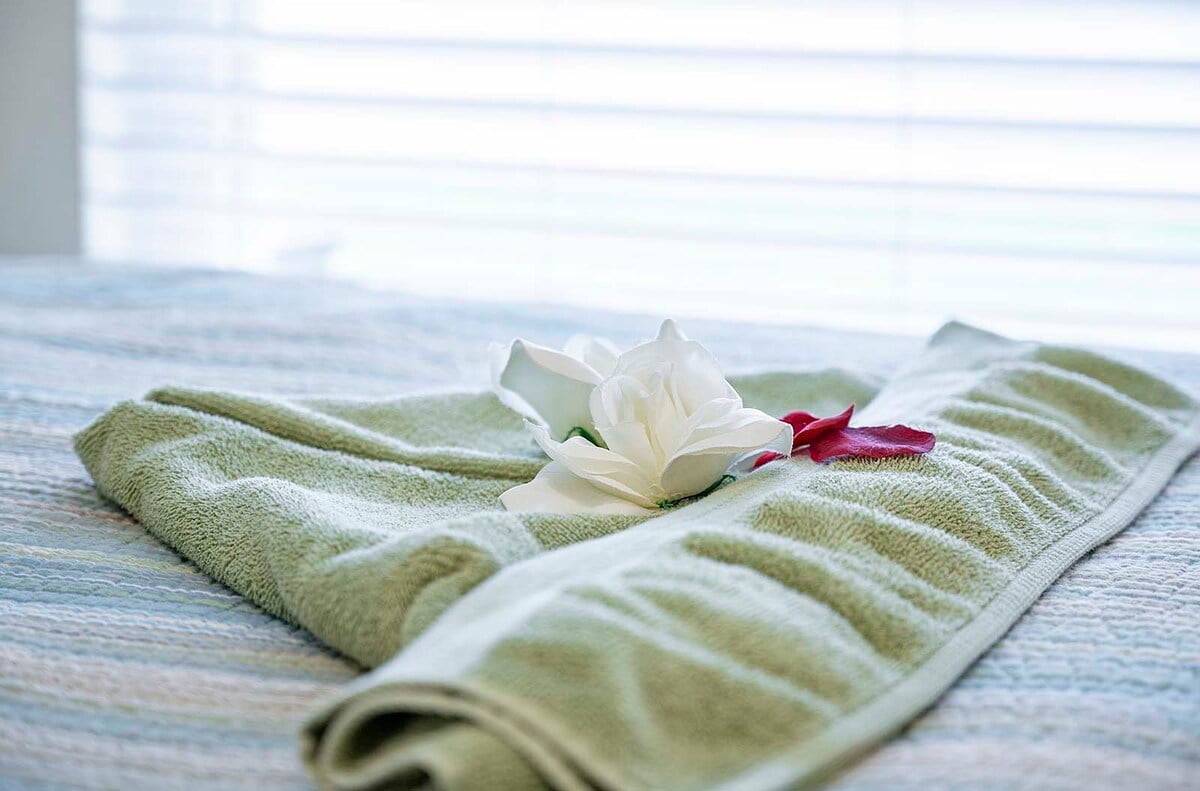 Sonniger Poolbereich mit Grill und eingezäuntem Garten.