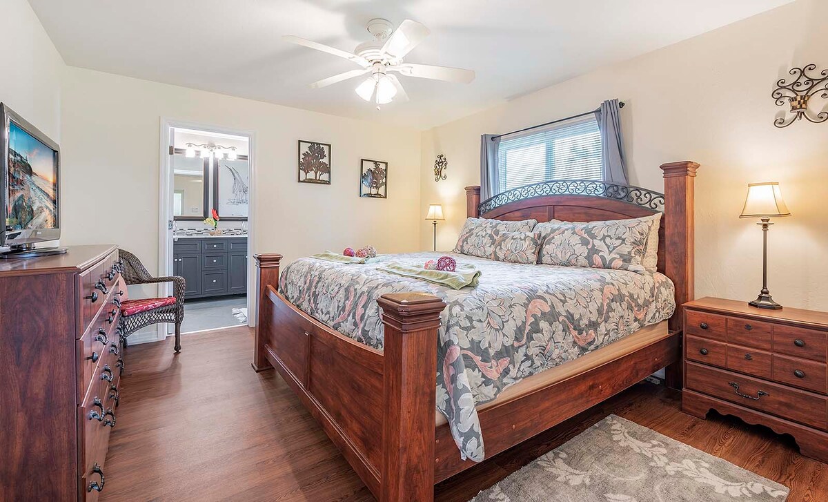 Sonniger Poolbereich mit Grill und eingezäuntem Garten.