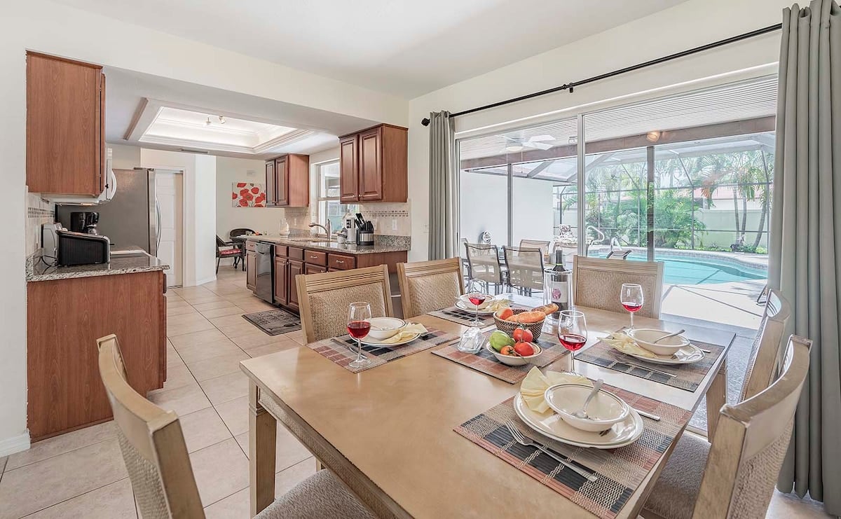 Sonniger Poolbereich mit Grill und Sitzplatz im eingezäunten Garten.