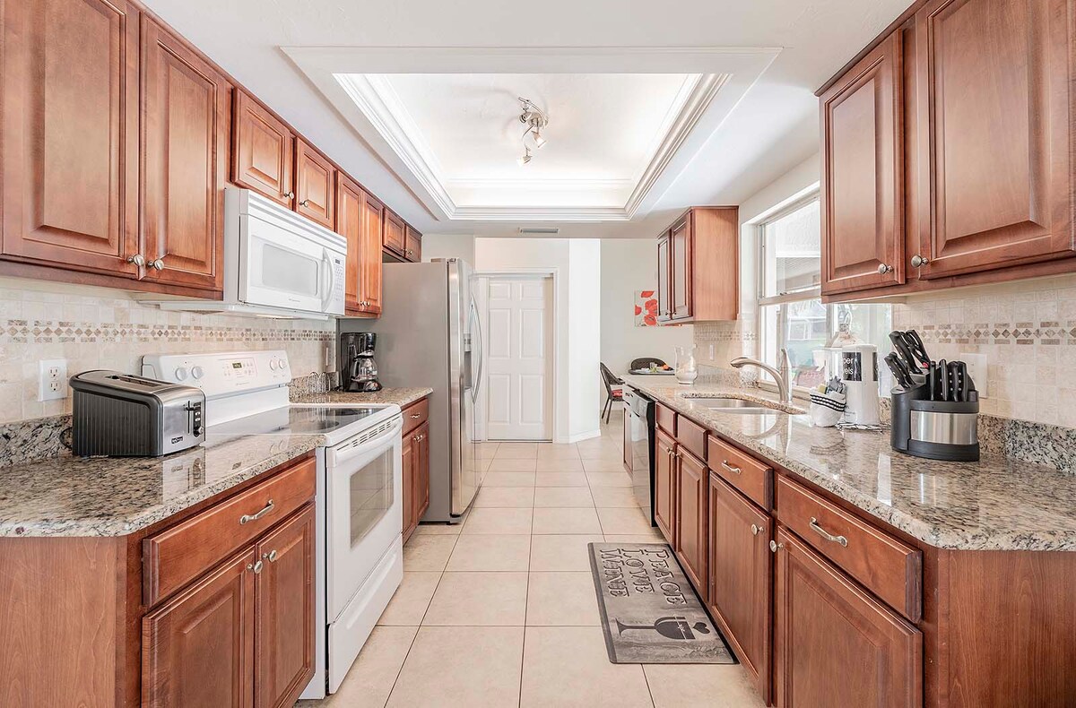 Außenbereich mit beheiztem Pool, Grill und eingezäuntem Garten.