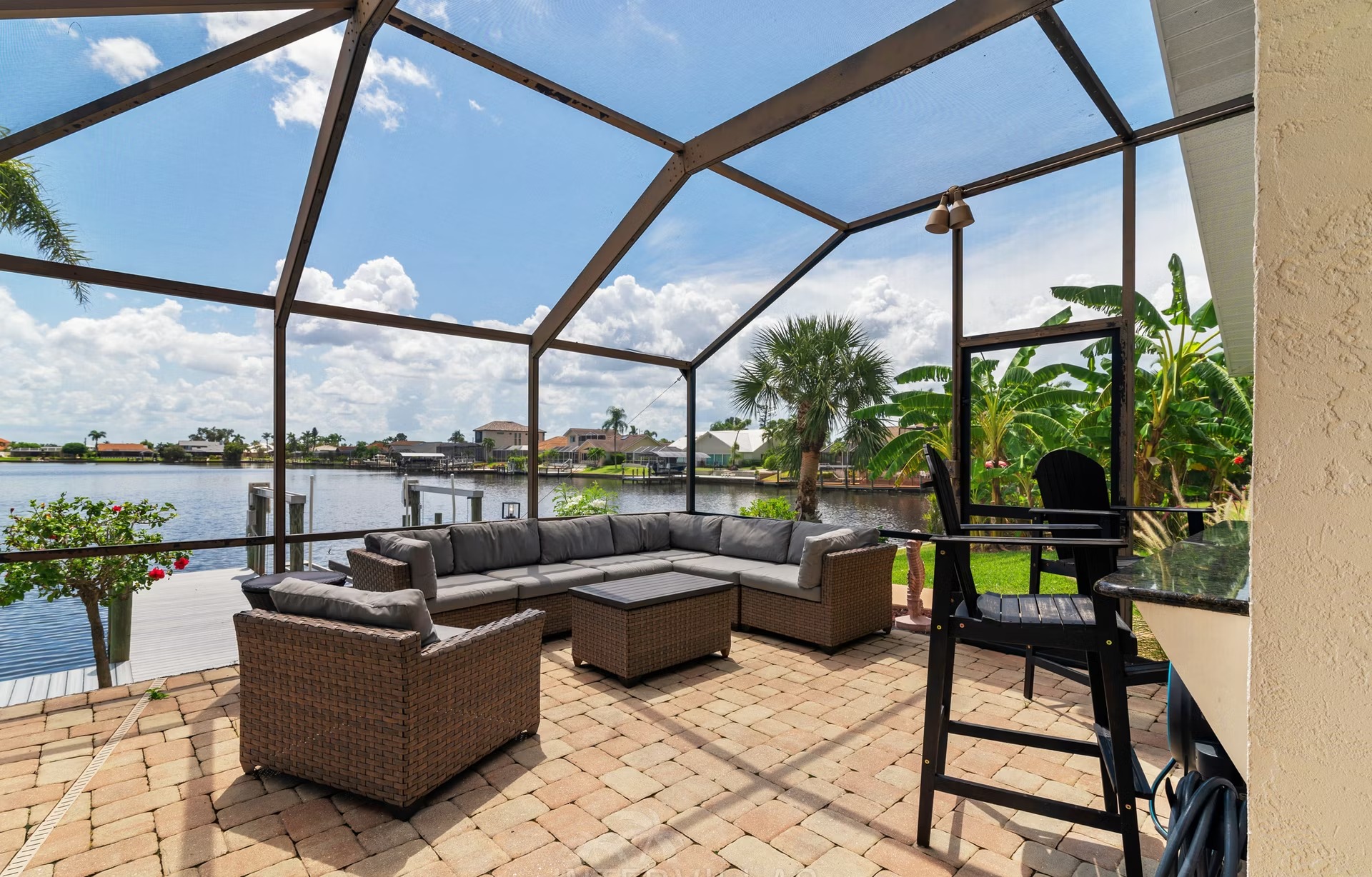 Beheizter Pool mit Sonnenliegen und Außenküche auf der Lanai mit Blick aufs Wasser.