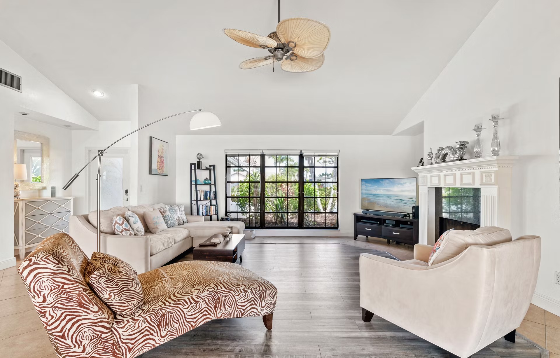 Beheizter Pool mit Sonnenliegen und überdachtem Sitzbereich mit Außenküche am Wasser.