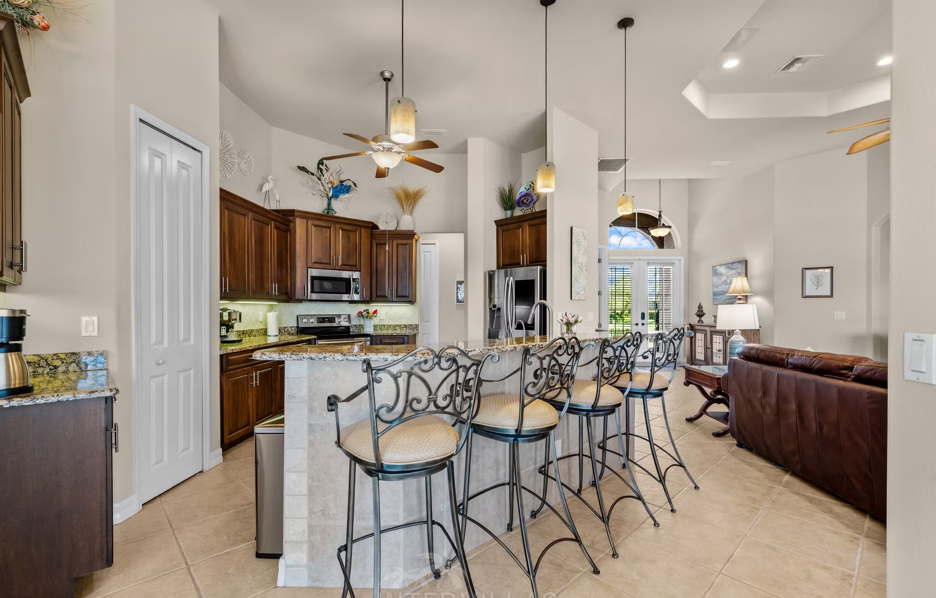 Überdachter Outdoor-Bereich mit Sitzgruppe und Blick aufs Wasser.