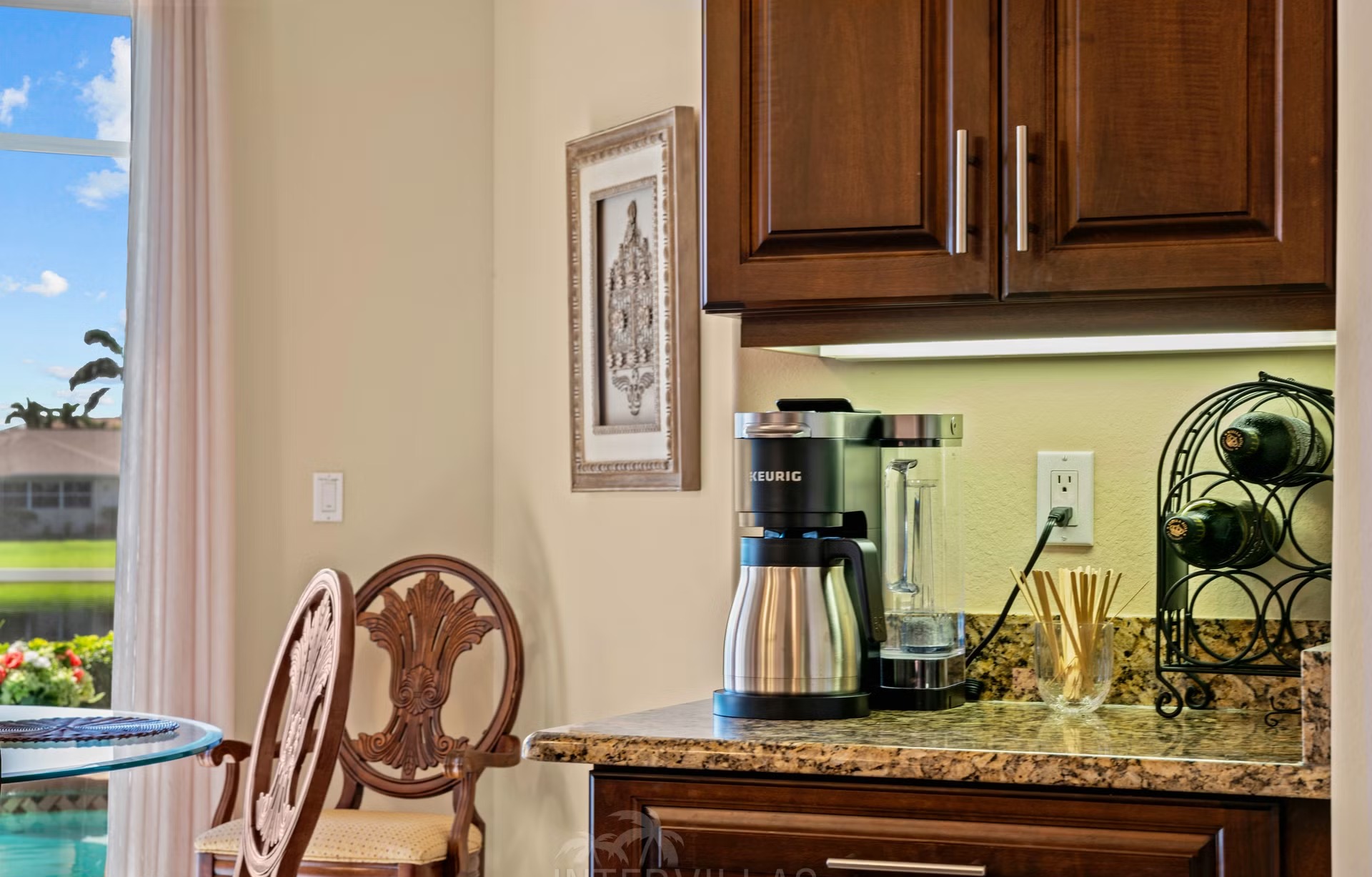 Überdachter Outdoor-Bereich mit Sitzgruppe und Blick auf den See.