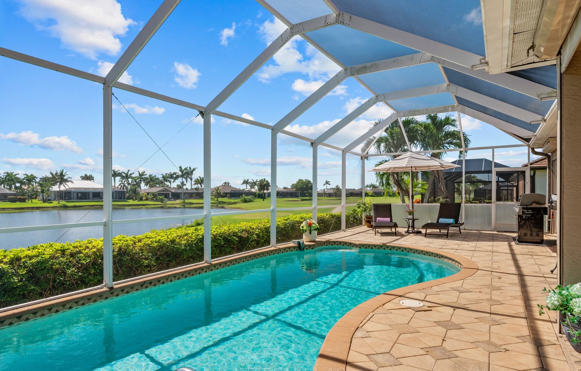 Überdachter Outdoor-Bereich mit Sitzgruppe und Blick auf den See.