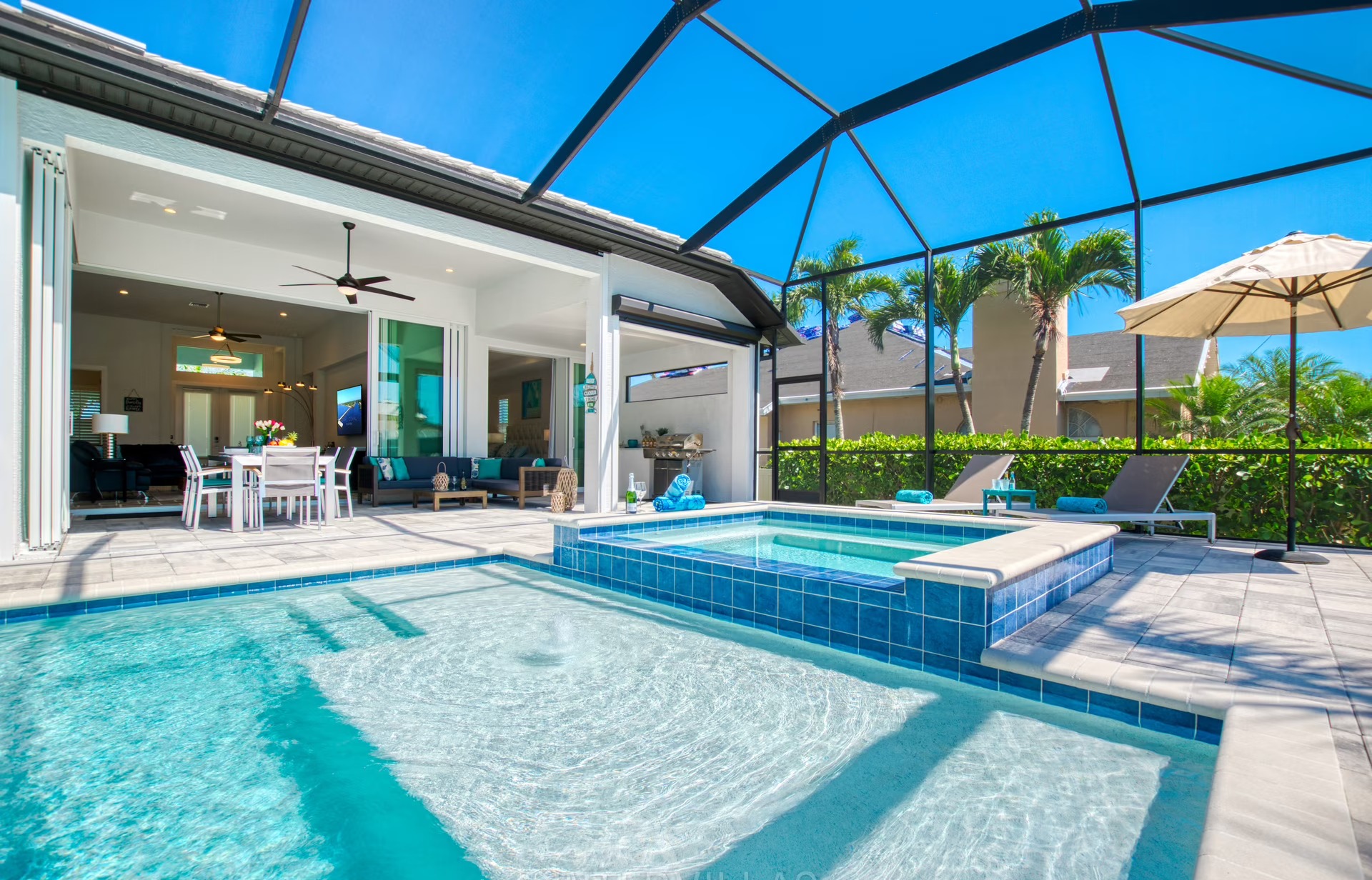 Westlich ausgerichteter Poolbereich mit beheiztem Pool, Jacuzzi und überdachtem Sitzplatz am Kanal.