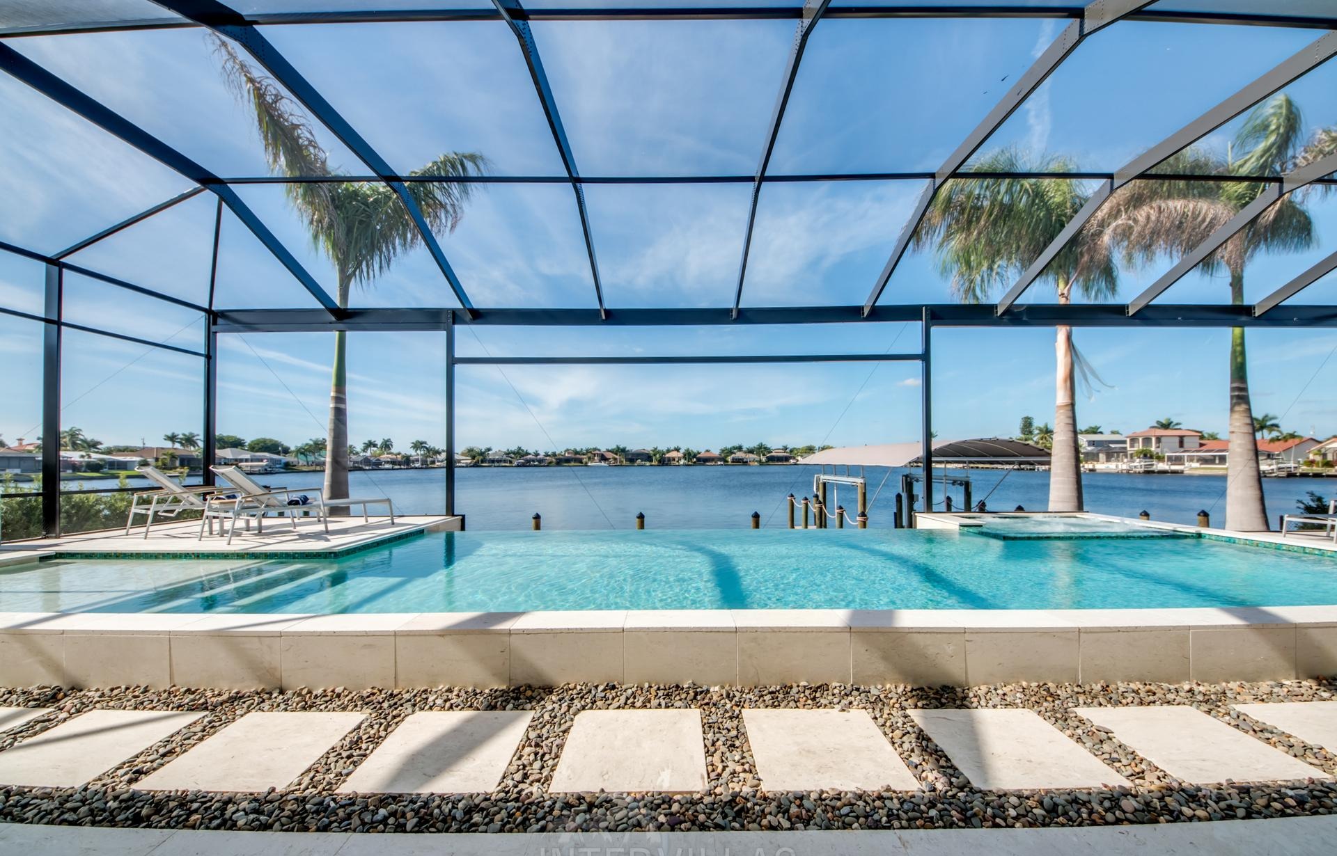 Westlich ausgerichteter Pool mit Spa und Blick auf den Kanal am privaten Bootssteg.