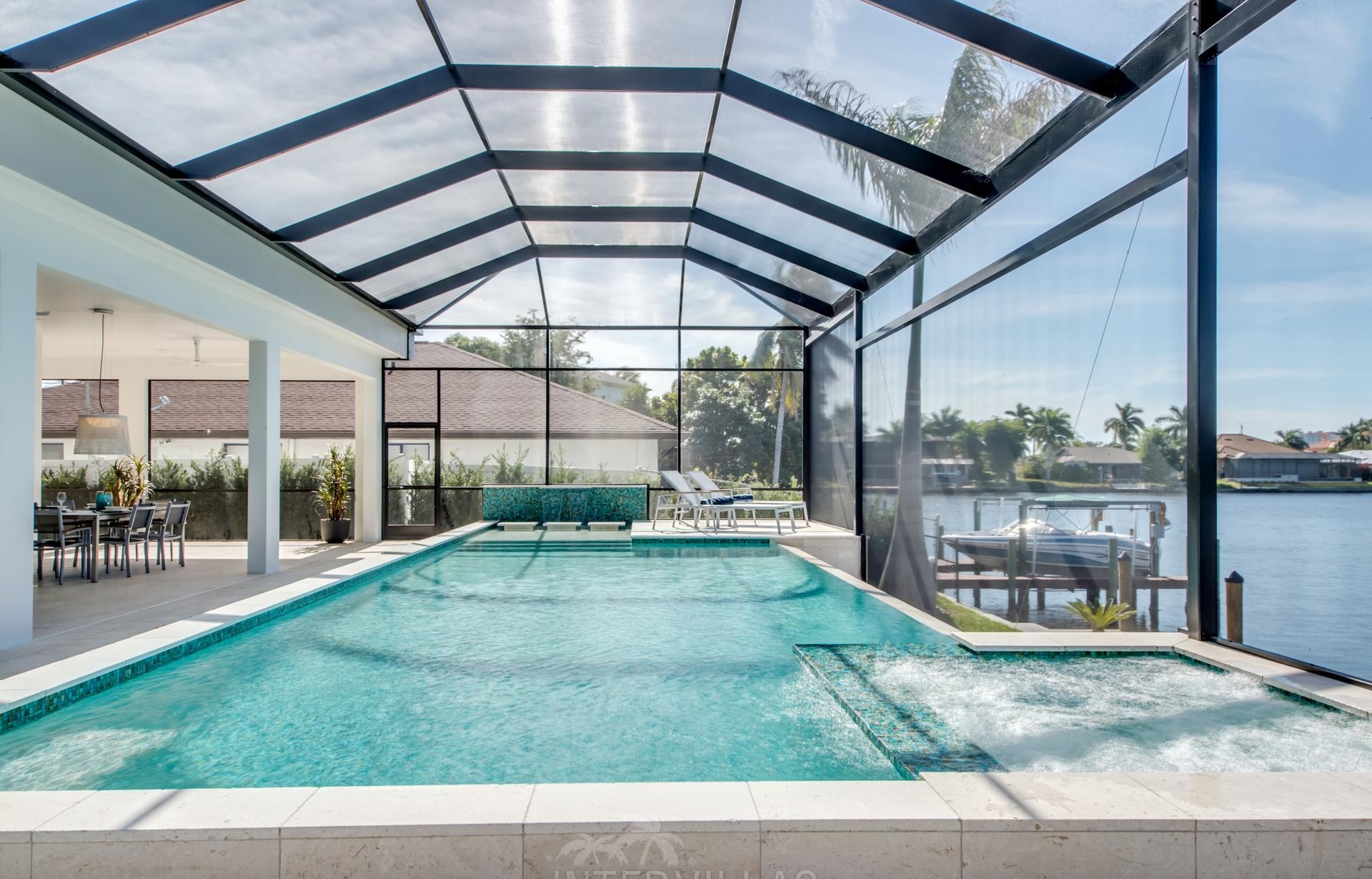 Westlich ausgerichteter Pool mit Spa am Kanal und privatem Bootssteg.