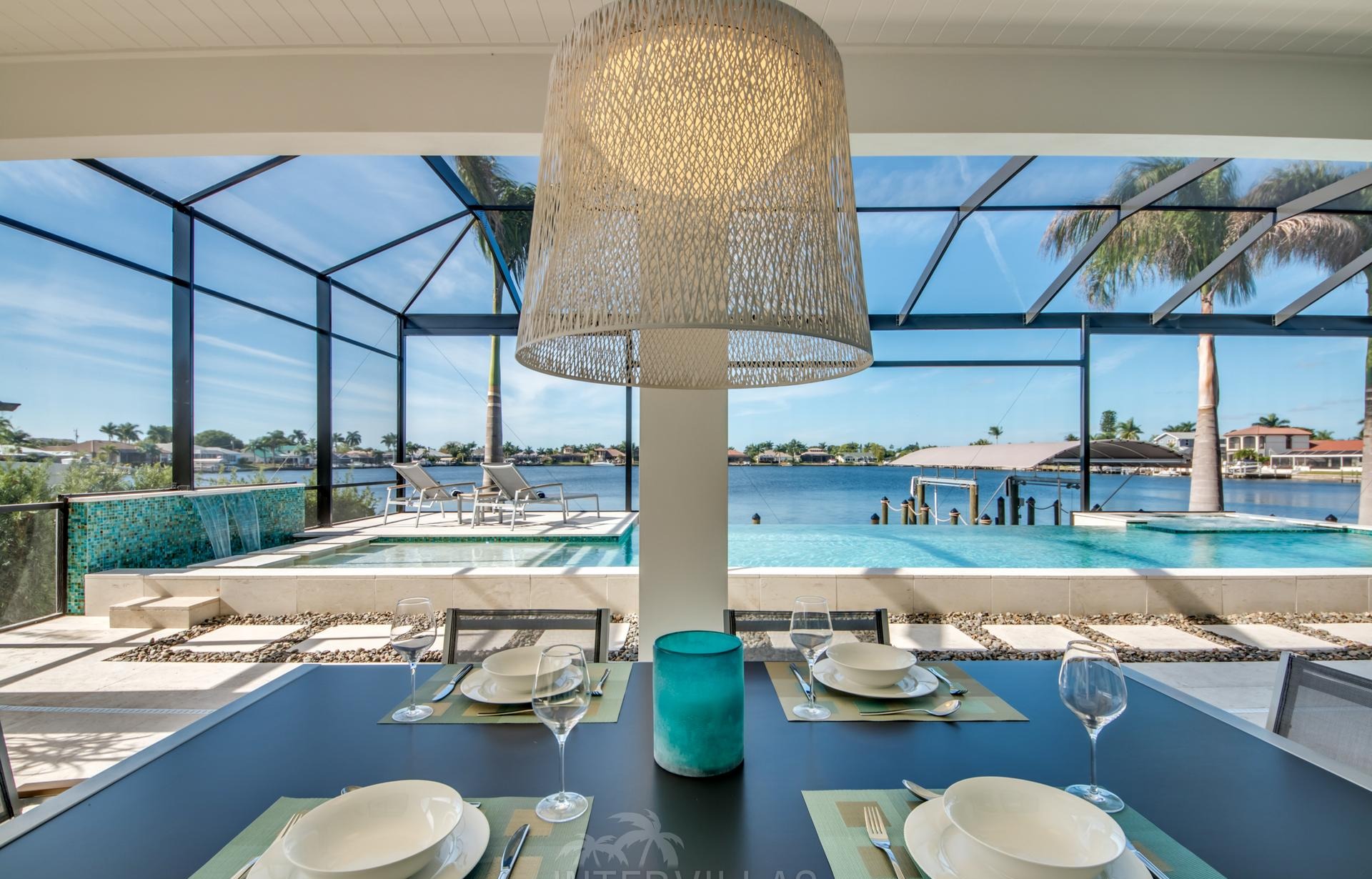 Moderner Poolbereich mit Spa/Jacuzzi und Blick auf den Kanal mit Bootsdock.