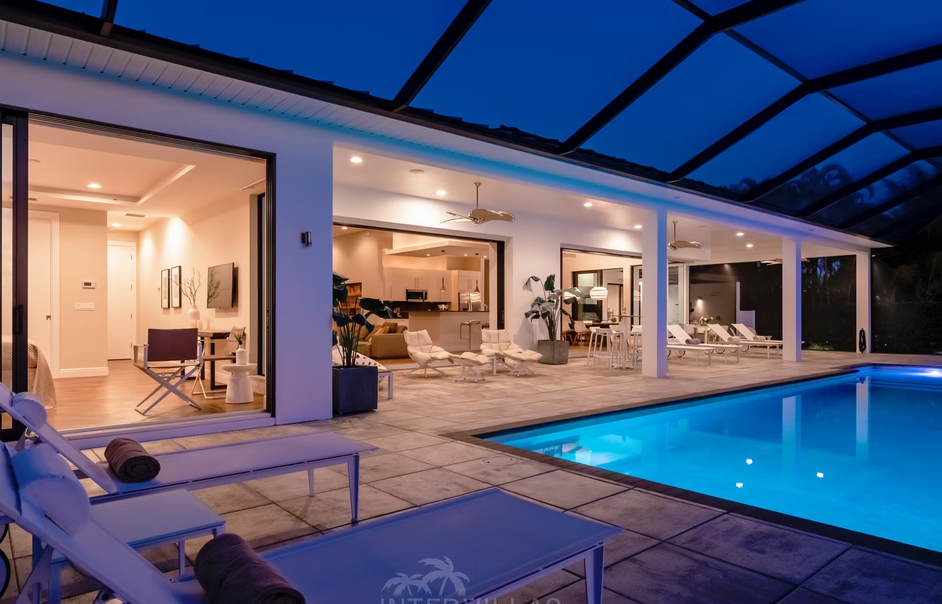 Infinity-Salzwasserpool mit Liegen und Blick auf den Kanal bei Sonnenuntergang.